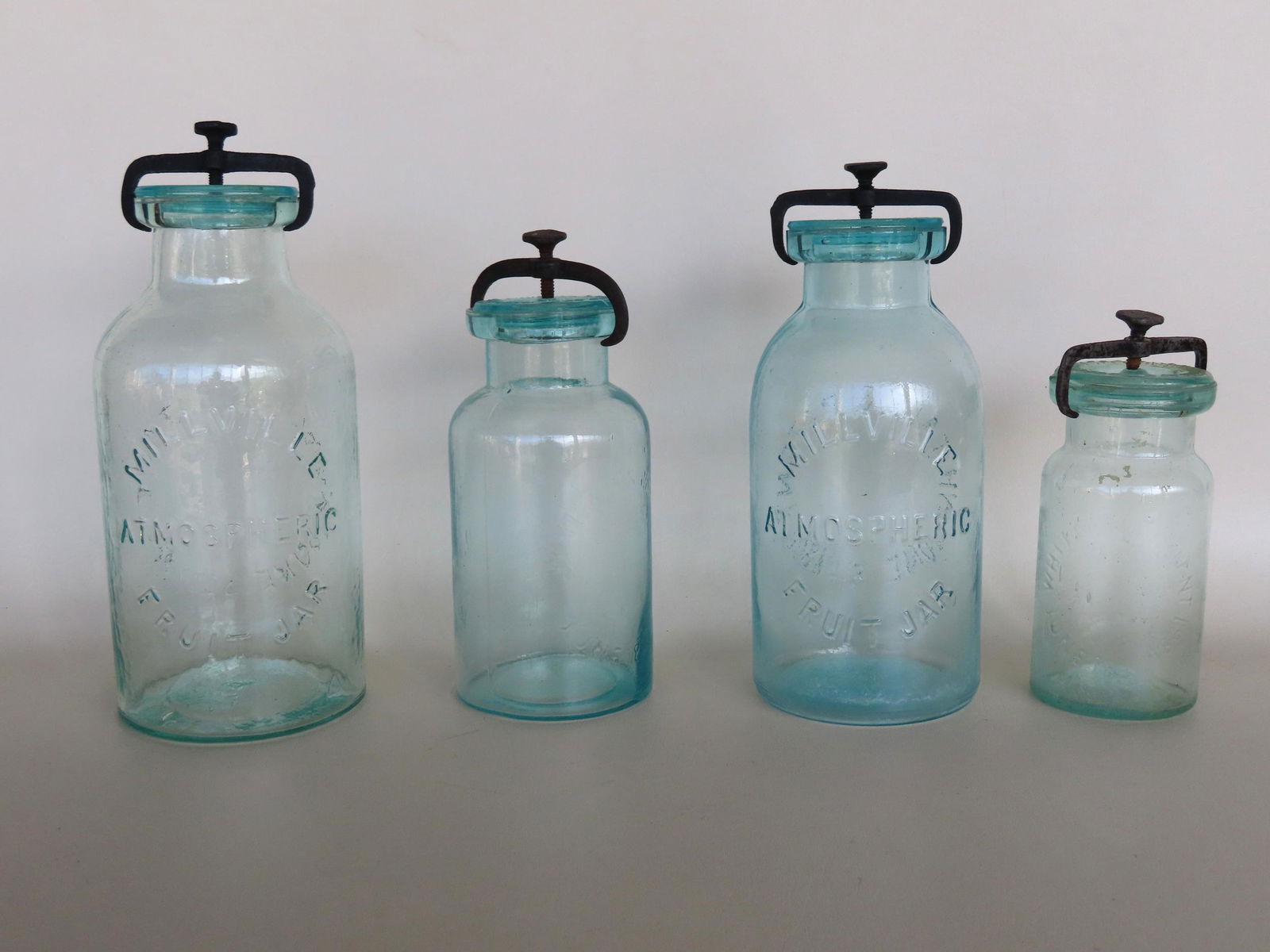 Four fruit jars with iron lid fasteners. Three signed "Millville Atmospheric Fruit Jar"; and the (1 of 6)