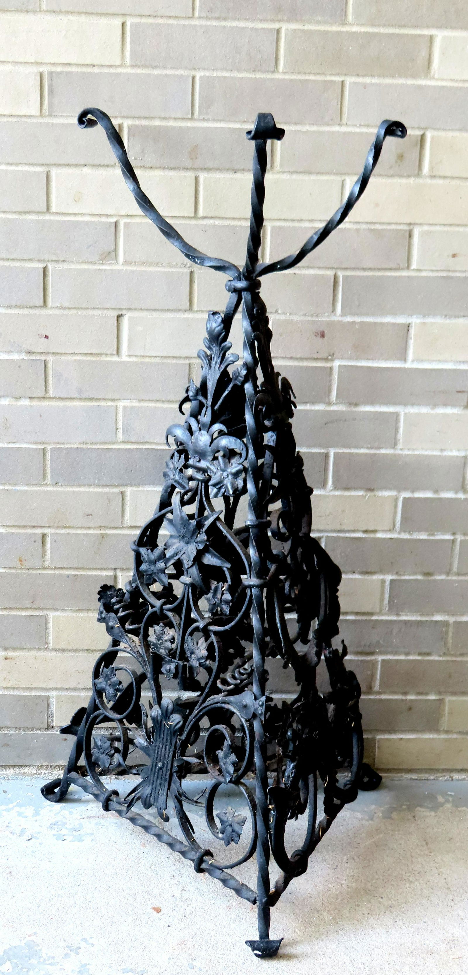 A fancy cast iron plant stand on hand forged triangular iron frame, profusely decorated with flowers (1 of 4)