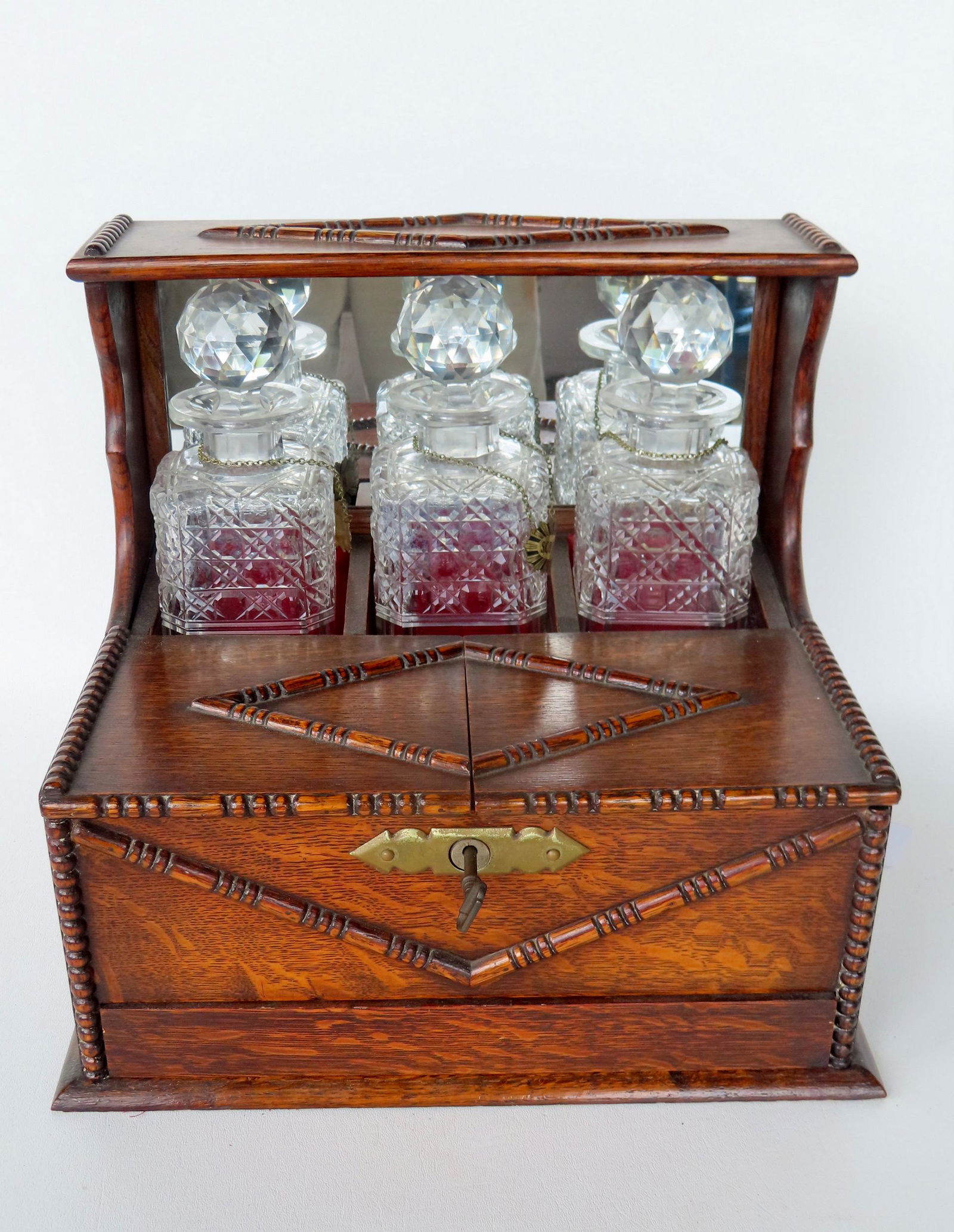 An exceptional oak tantalus with 3 cut glass decanters for Scotch, Rye and Bourbon and having a (1 of 12)