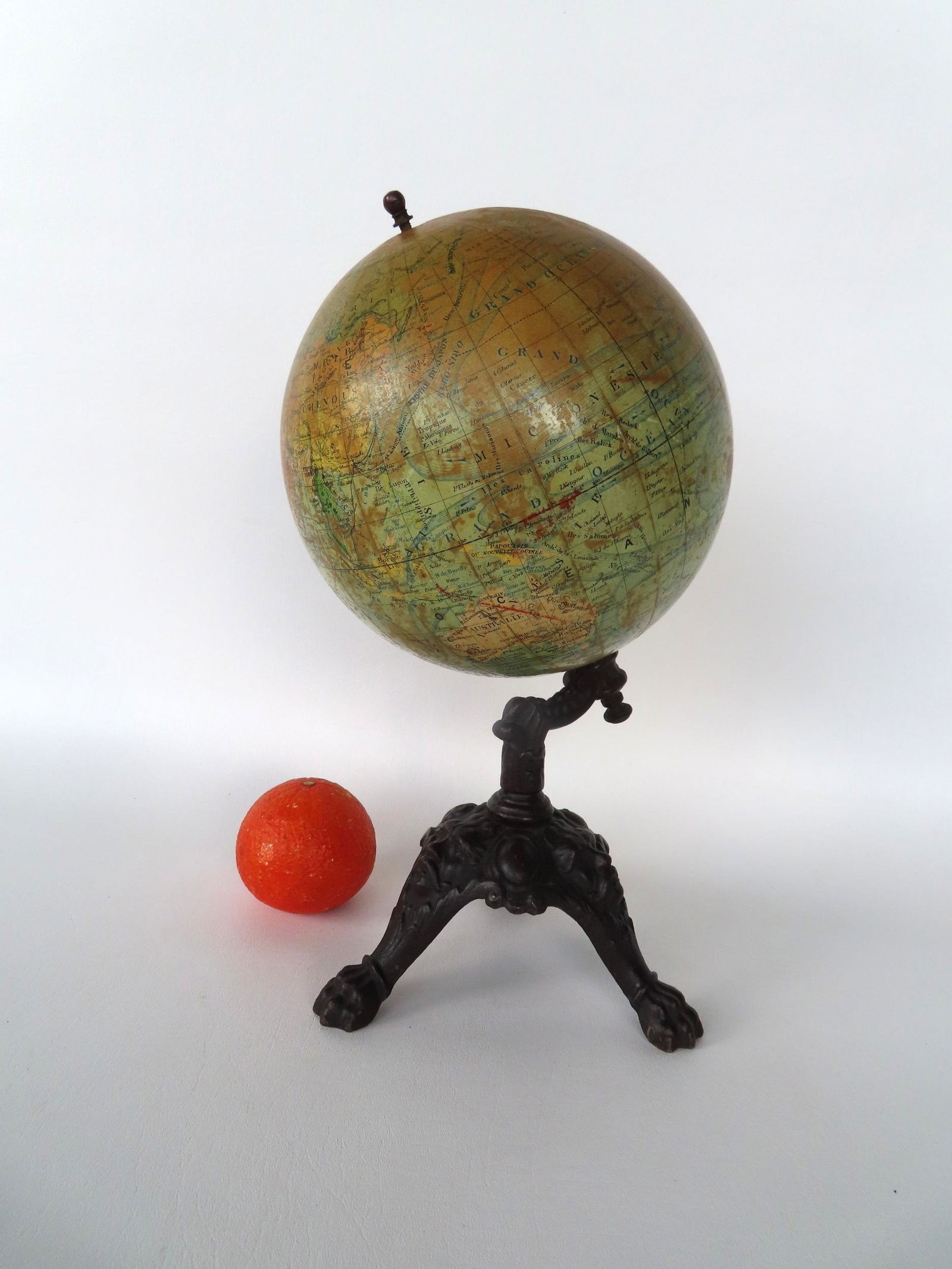 Terrestrial globe on cast iron tri-foot base with claw feet - the stand also decorated with faces. (1 of 9)