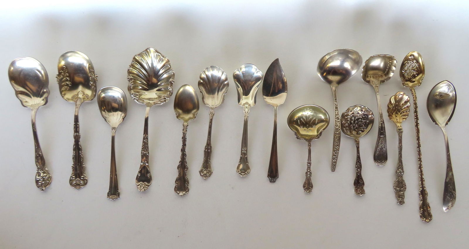 Grouping of 15 sterling silver serving spoons and ladles. The largest with gold wash measures 9"L x (1 of 4)