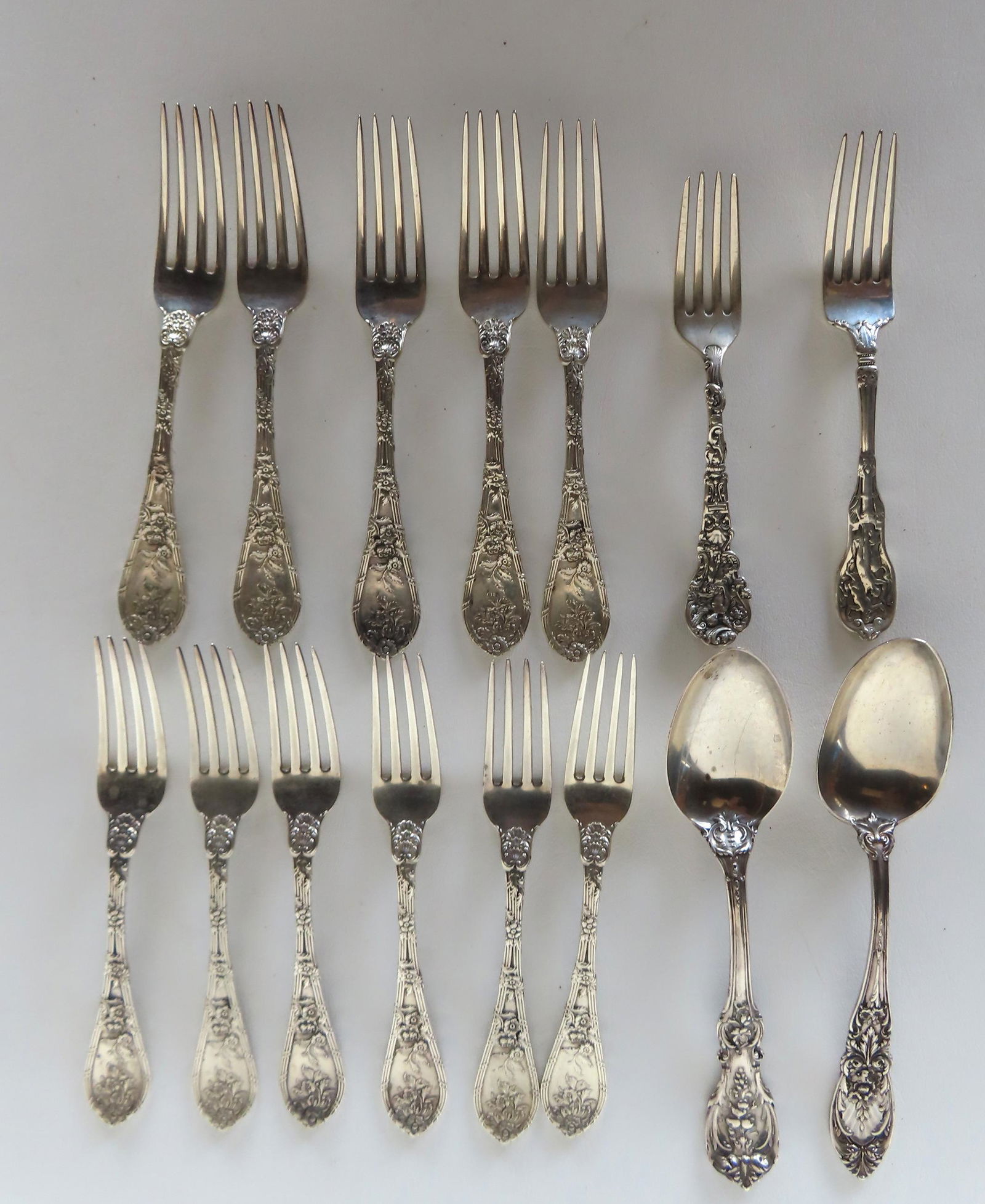 Grouping of 14 ornate sterling silver flatware pieces including: 10 matching dinner forks decorated (1 of 7)