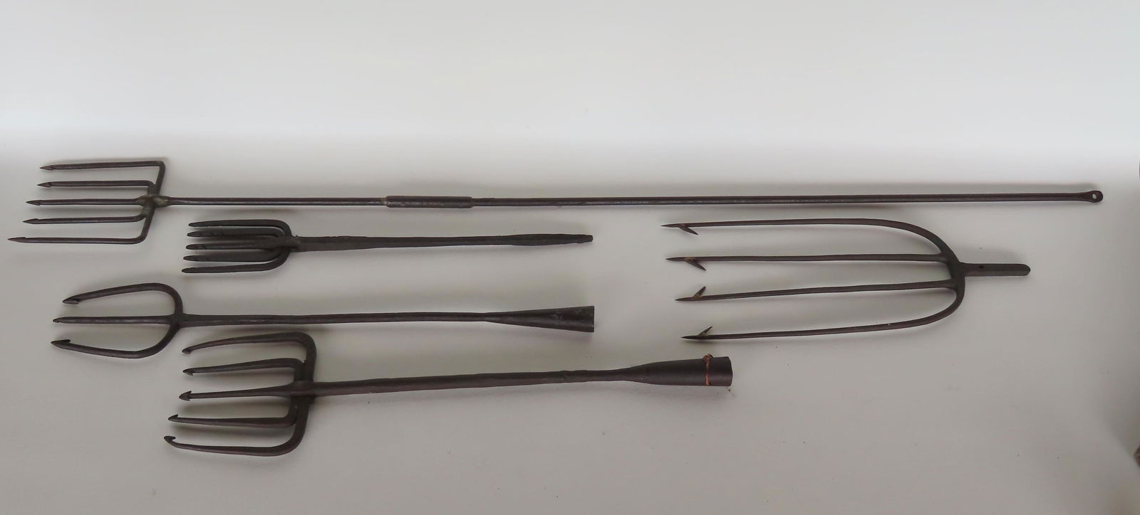 A grouping of 5 eel and fish spears, 4 being hand forged iron. The largest in wrought iron measures (1 of 2)