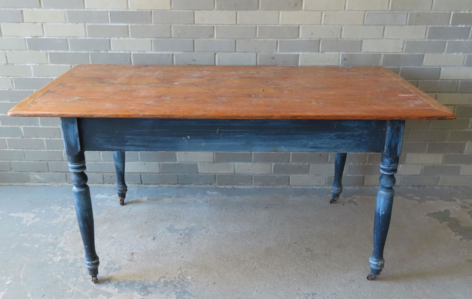 A farm table with painted legs and scrubbed pine top having bread-board ends. The top likely a (1 of 5)