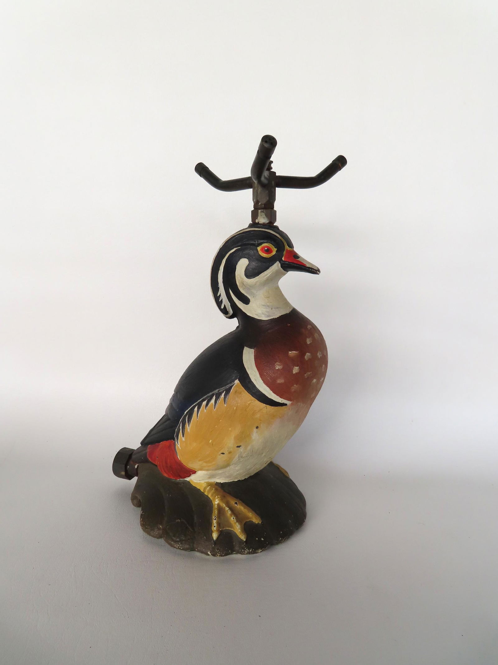 A cast iron wood duck lawn sprinkler sitting on top of a clam shell and signed "NUYDEA". This (1 of 7)