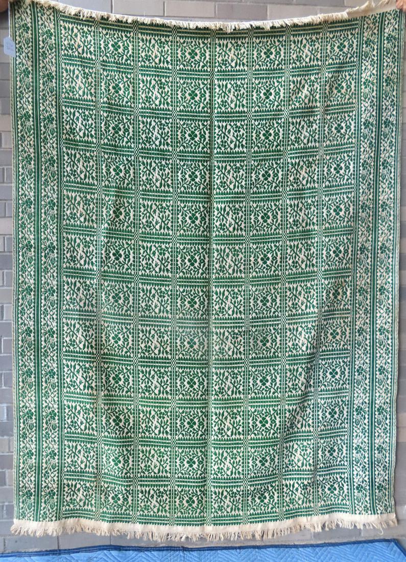 A green and white woven coverlet, decorated with floral sprigs within fenced blocks and having (1 of 3)