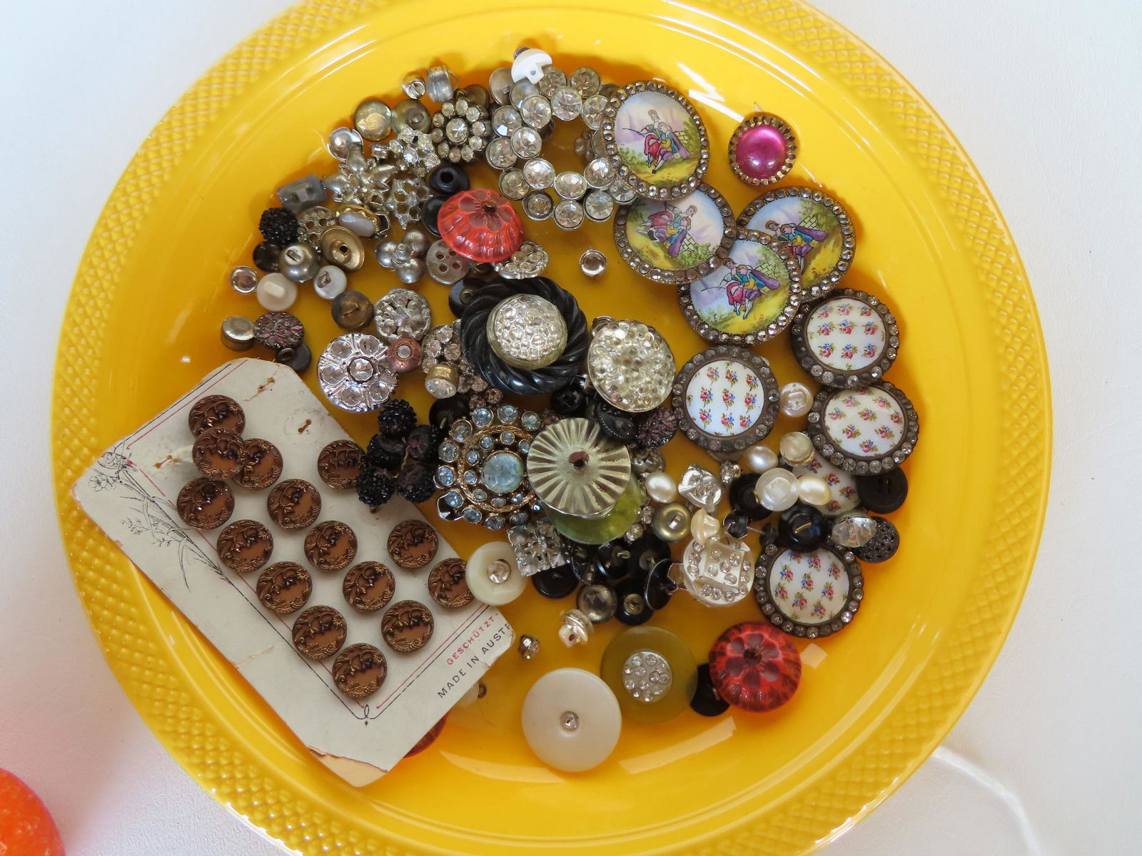A grouping of vintage buttons including: Matched set of 4 with hand painted courting scene and (1 of 5)