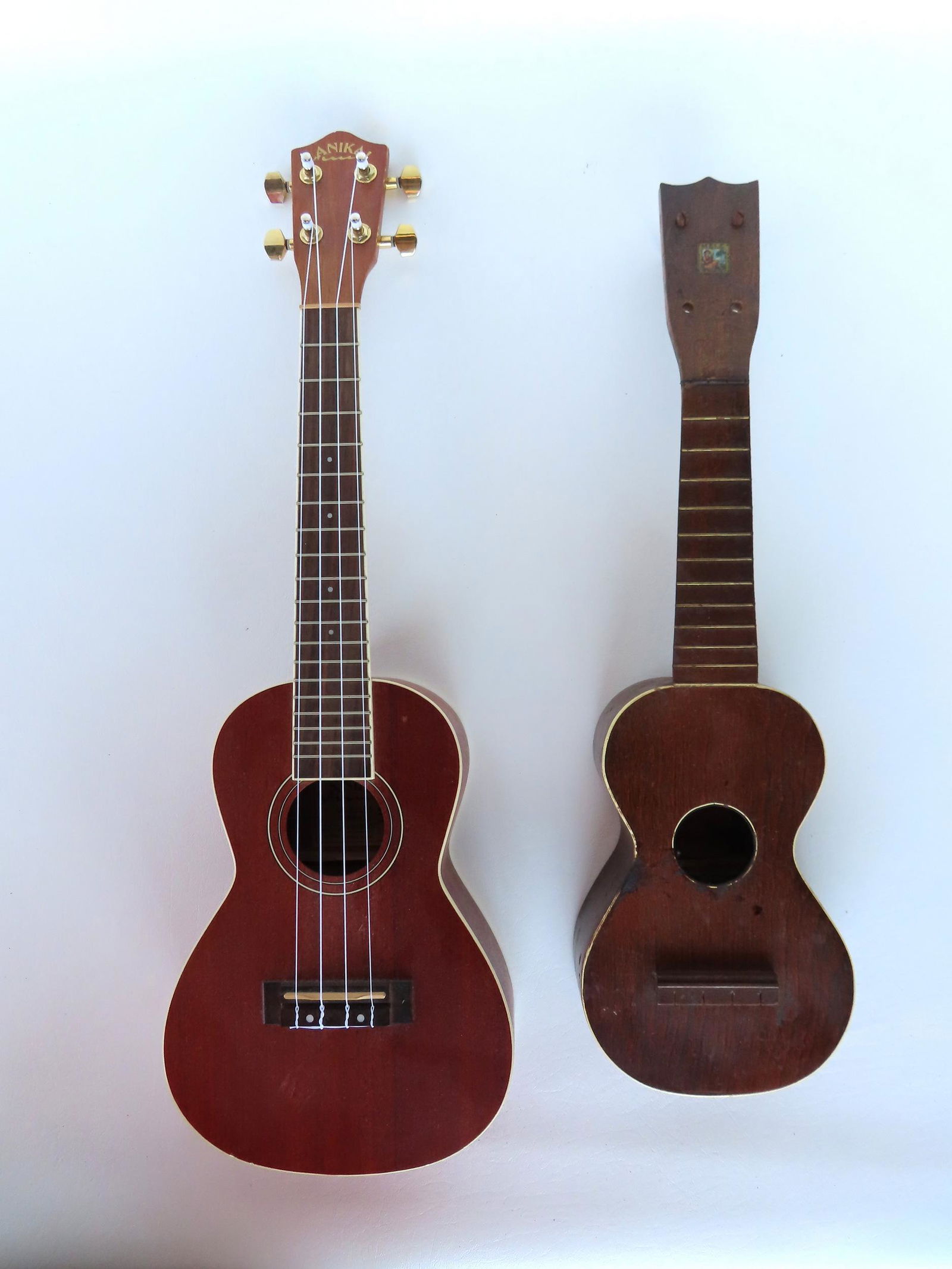 Two ukuleles including: 1) Hawaiian signed Lanikai, good working condition - measures 7 3/4"W x 24" (1 of 4)