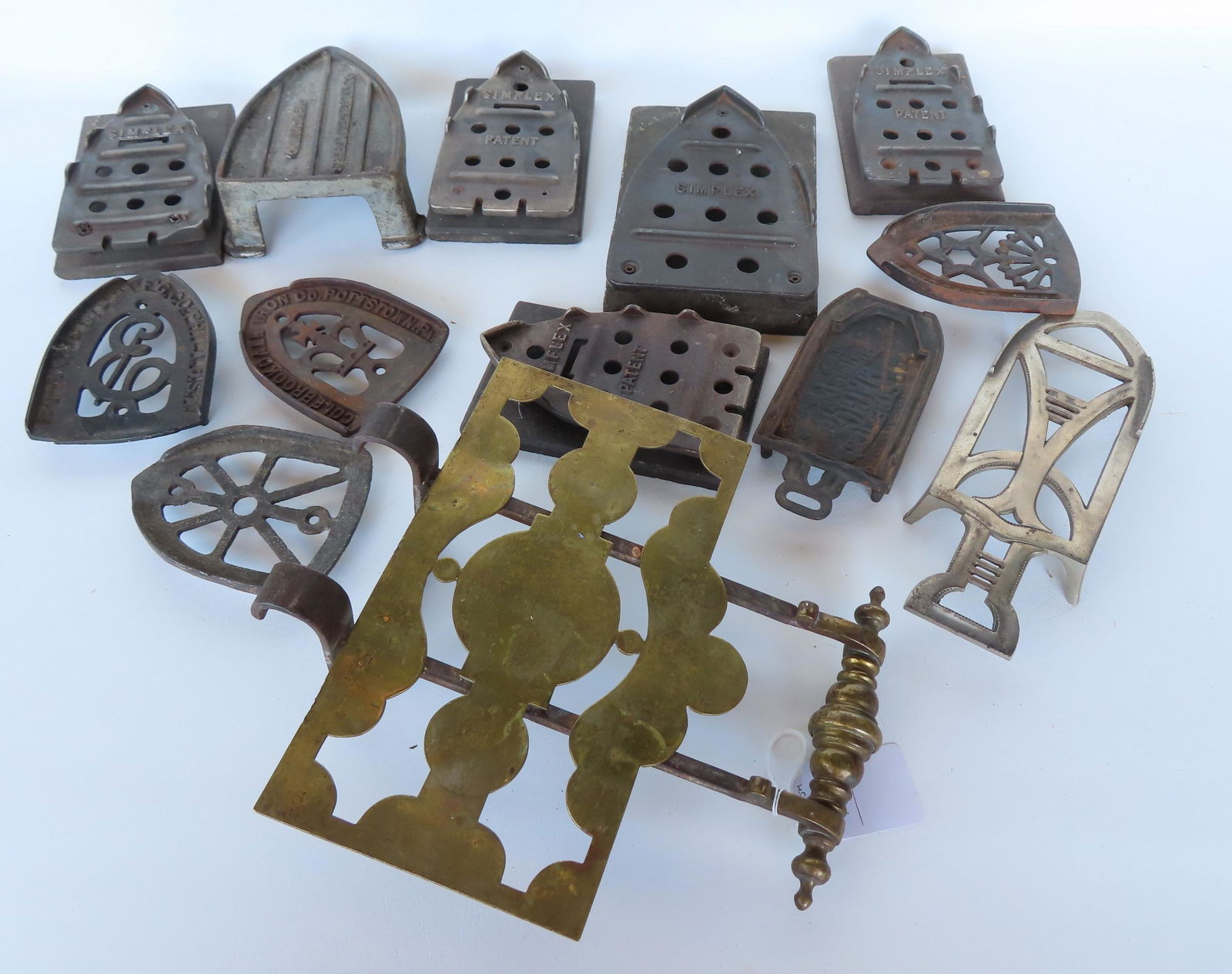 Large grouping of vintage iron trivets and an early adjustable brass and iron fireplace trivet, (1 of 8)