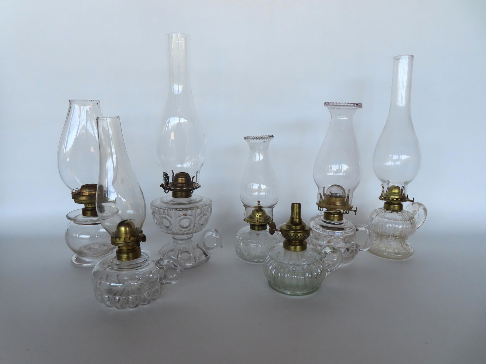 Grouping of 7 pressed and blown finger oil lamps with a variety of different style burners, mid to (1 of 4)