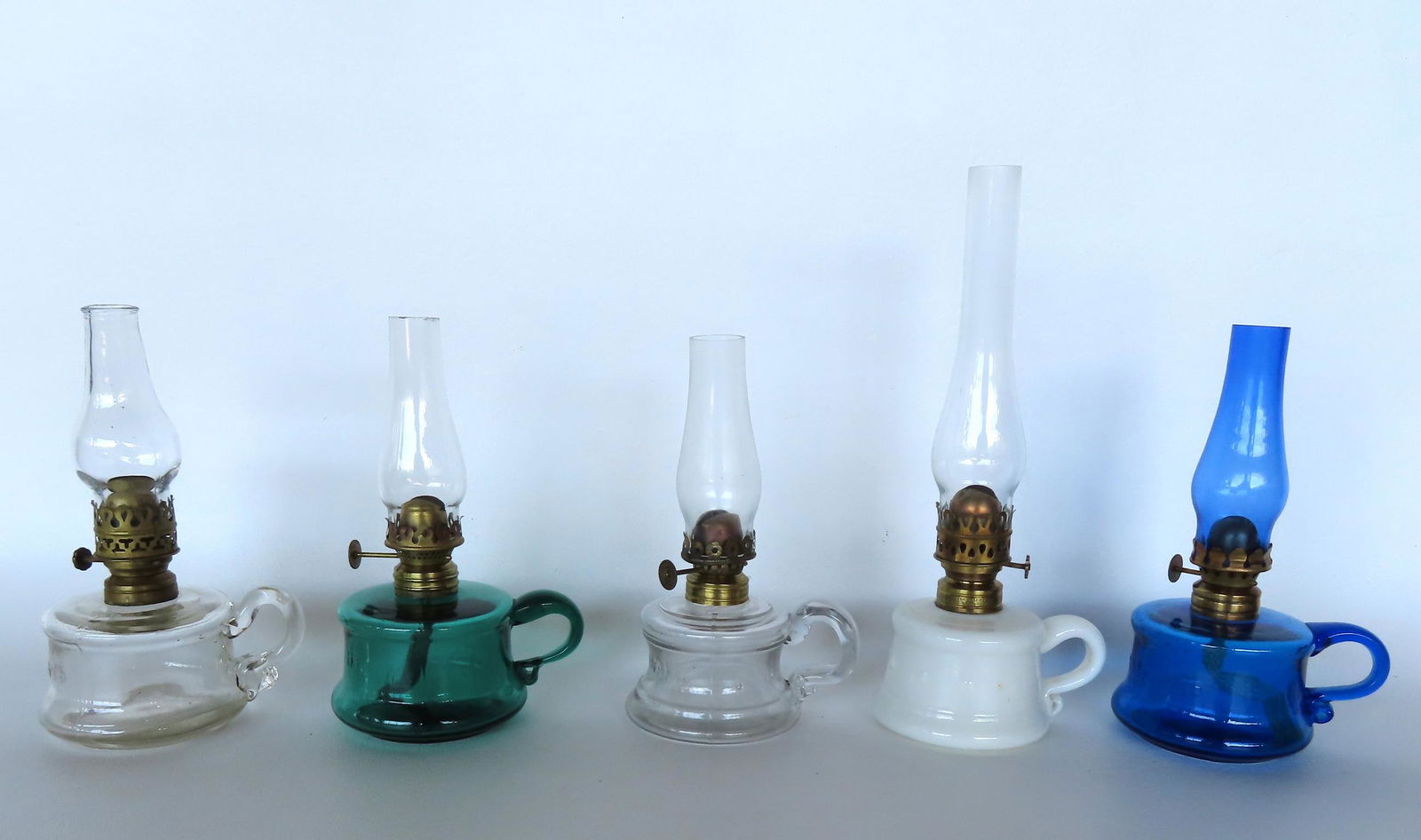 Grouping of 5 miniature oil lamps with fingers in various colors including 3 signed "Little Butter (1 of 8)