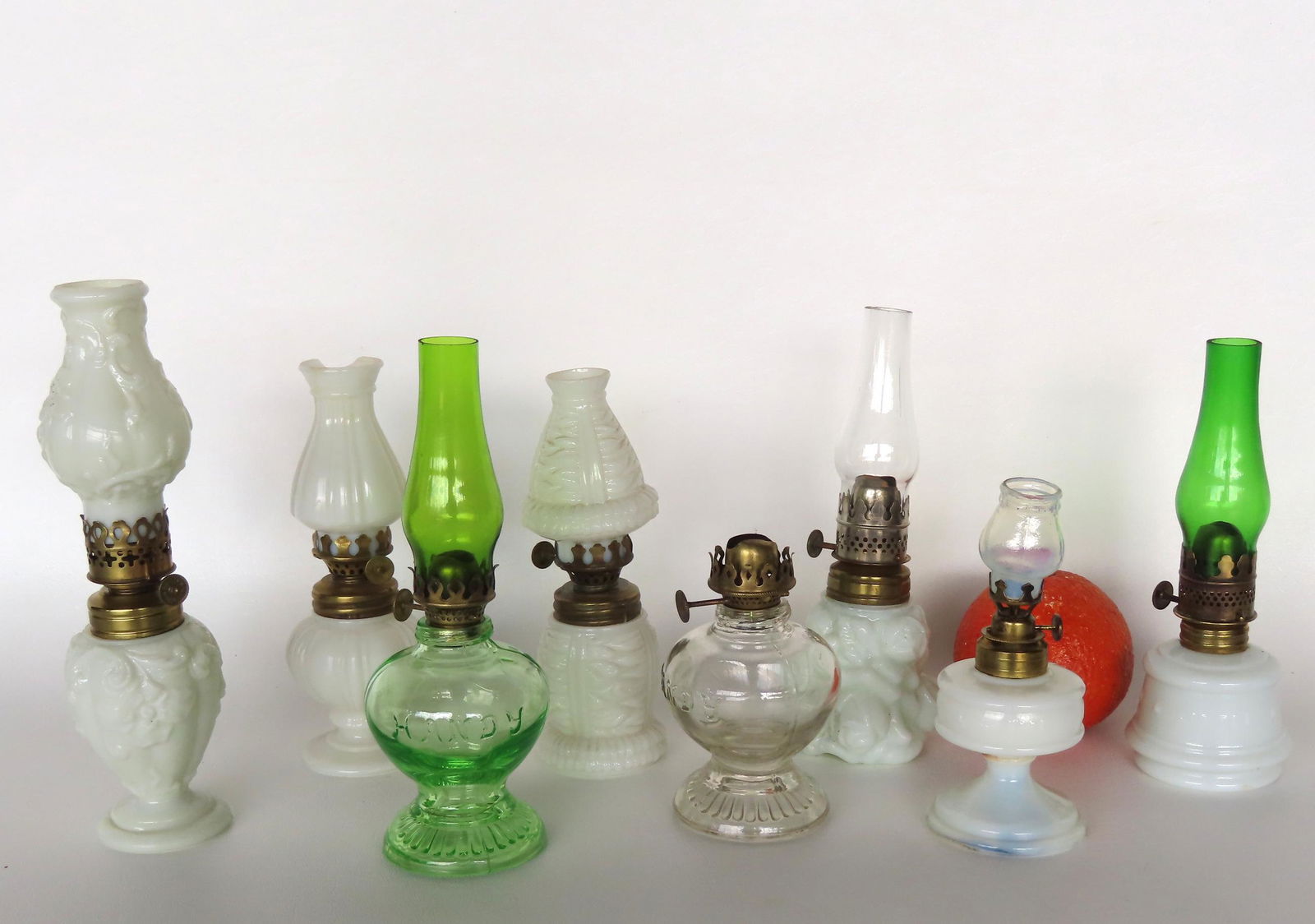 Grouping of 8 miniature oil lamps including: White milk glass signed "Banner Improved" - words: Grouping of 8 miniature oil lamps including: White milk glass signed "Banner Improved" - words separated by embossed stars - small chips along edge of base, else good condition; two on footed base sig