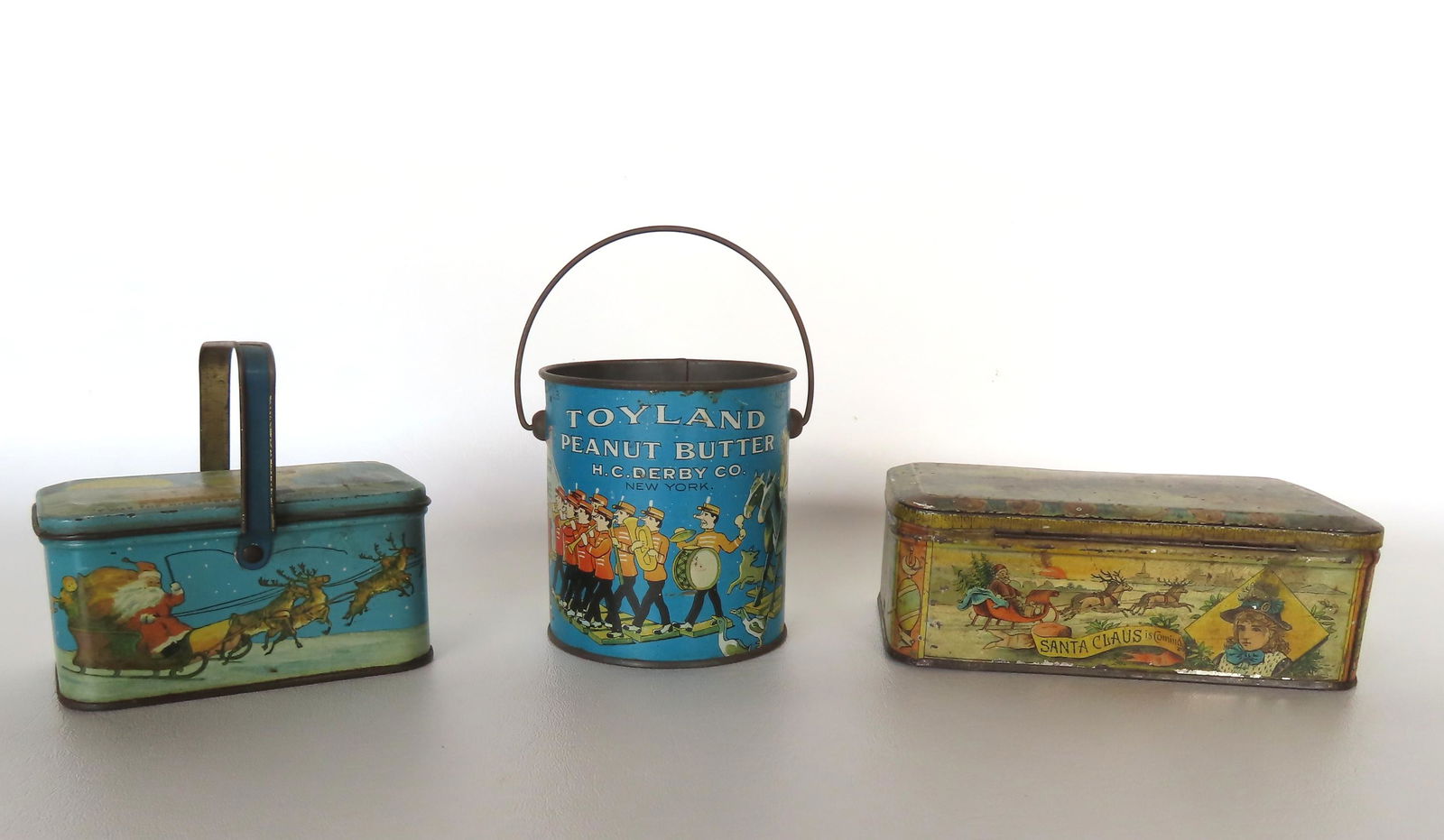 Three vintage lithograph tins including: A Christmas candy tin with carrying handle, marked "'twas (1 of 9)