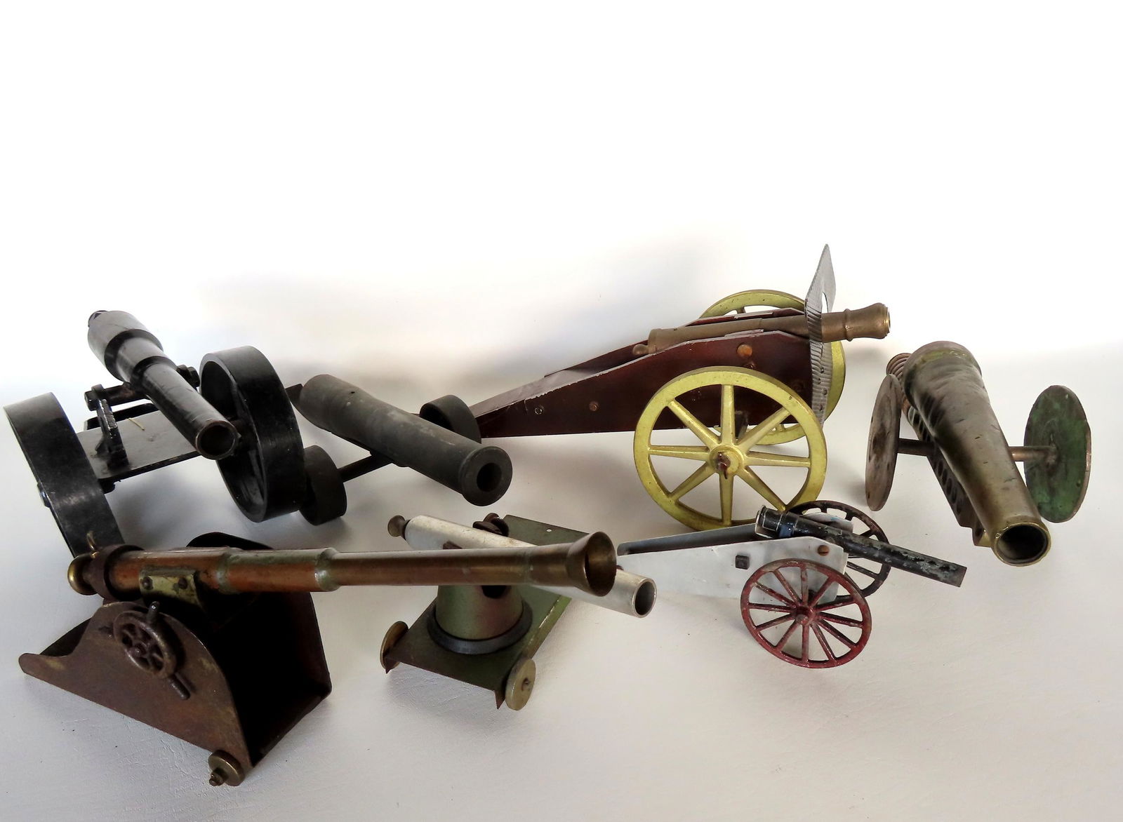 Grouping of 7 make-do metal toy cannons in brass, iron and tin. Several are toys, but 2 possibly (1 of 20)