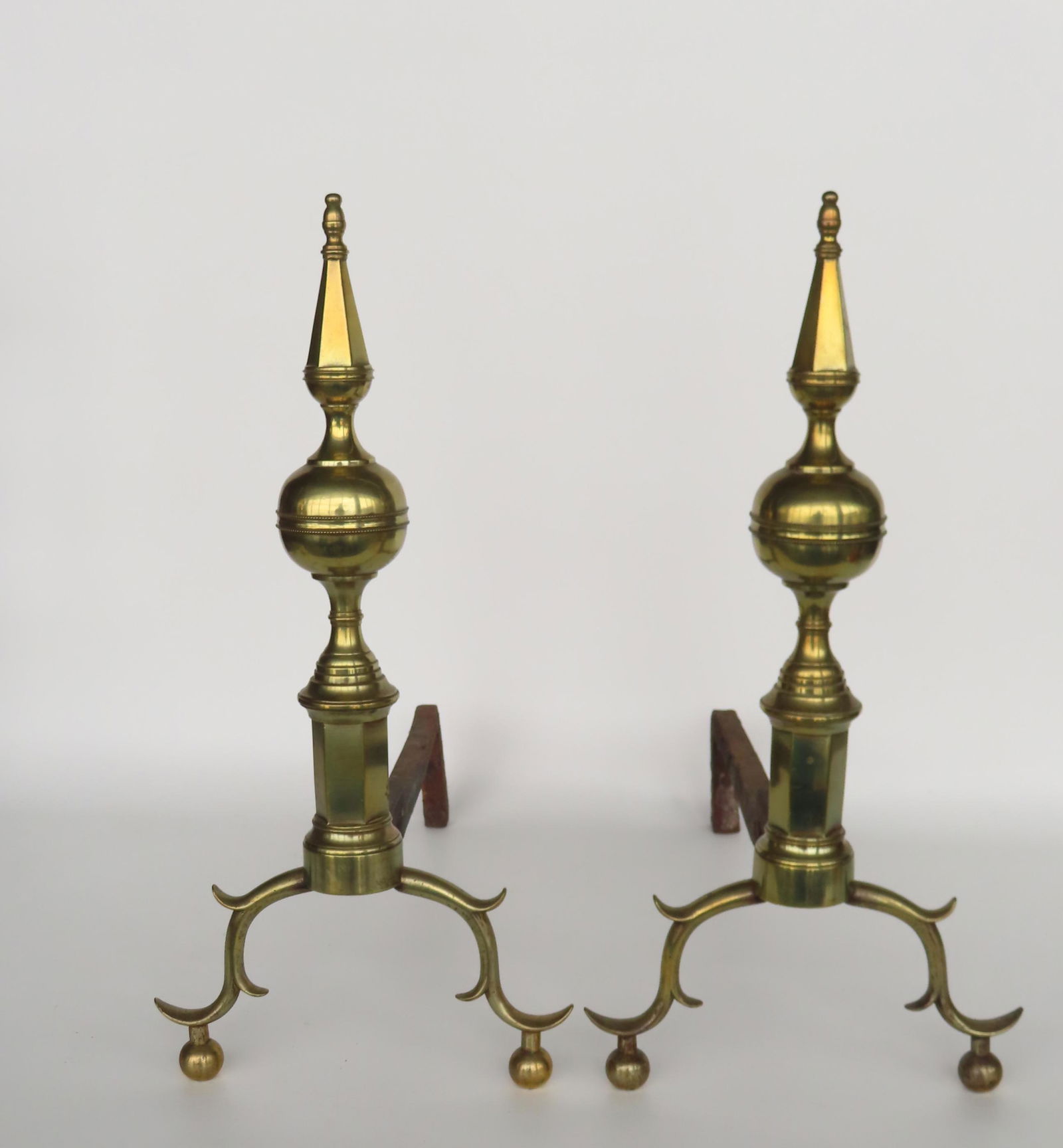 A good pair of signed NY Chippendale steeple top brass andirons having hexagonal shaped plinths: A good pair of signed NY Chippendale steeple top brass andirons having hexagonal shaped plinths above spurred legs leading to ball feet. The original fire dogs with an impressed signature of maker tha
