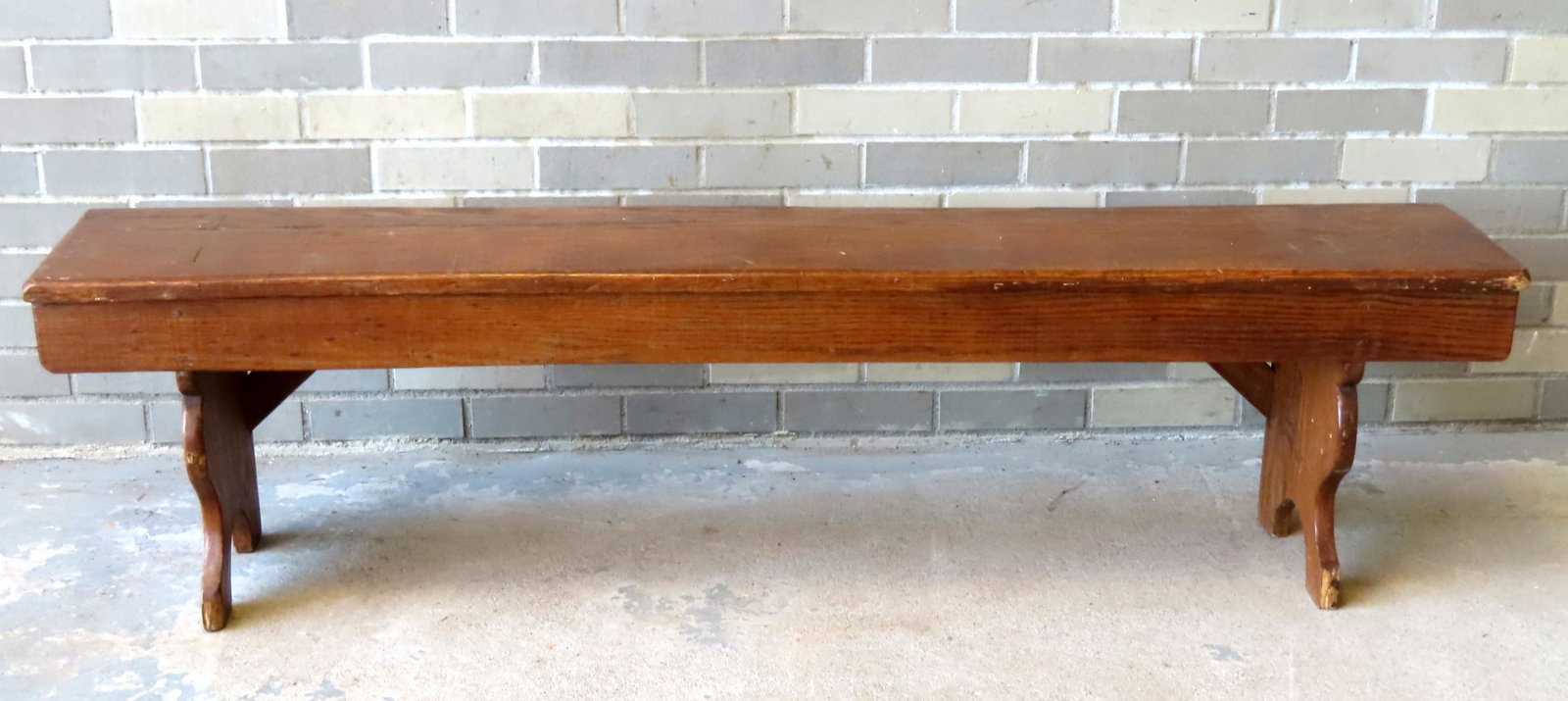 A primitive bench with see-through mortise construction, half moon cutouts on sides, shaped front: A primitive bench with see-through mortise construction, half moon cutouts on sides, shaped front and support stretchers on reverse side. VEr62 3/4"L x 11 1/2"W x 16 1/4"H. Very good refinished condit