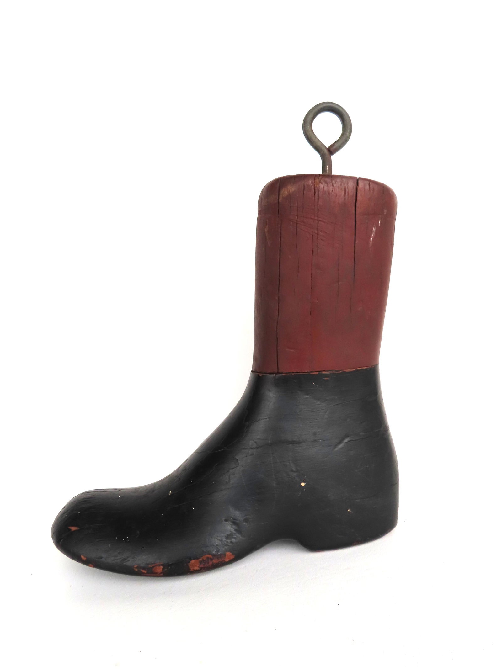 A carved wooden cobbler's trade sign in the form of a boot.: A carved wooden cobbler's trade sign in the form of a boot - the black and red paint appears to be original, 19th century. Very good condition. Measures 12"L x 4 1/4"W x 14 1/2"H.