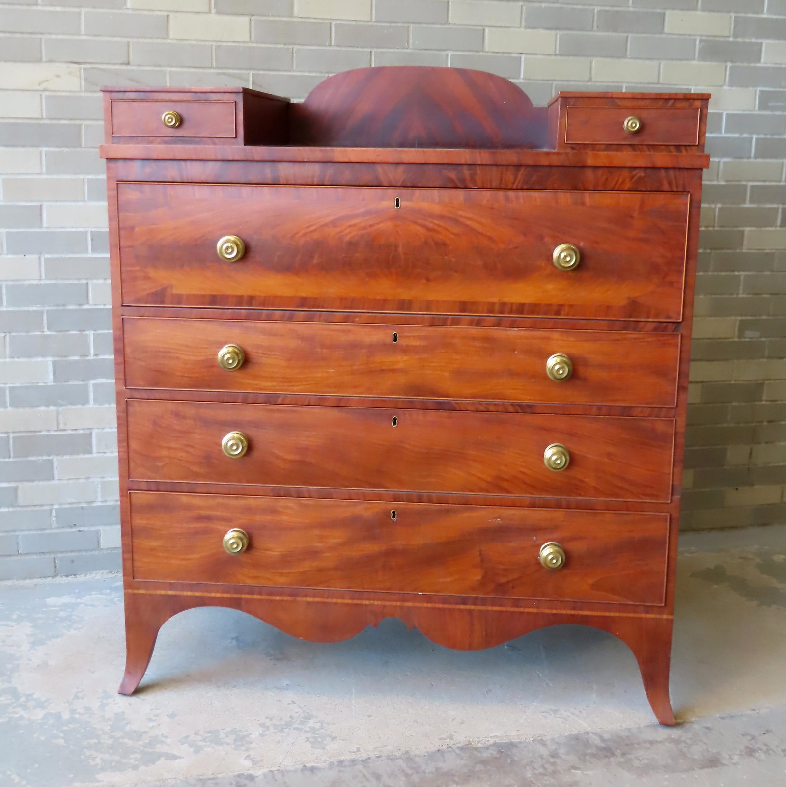 A very fine Hepplewhite mahogany chest of drawers having 2 glove drawers and domed backsplash on top: A very fine Hepplewhite mahogany chest of drawers having 2 glove drawers and domed backsplash on top over 1 large drawer with banded border, over 3 graduated drawers on beautiful cutout base with line