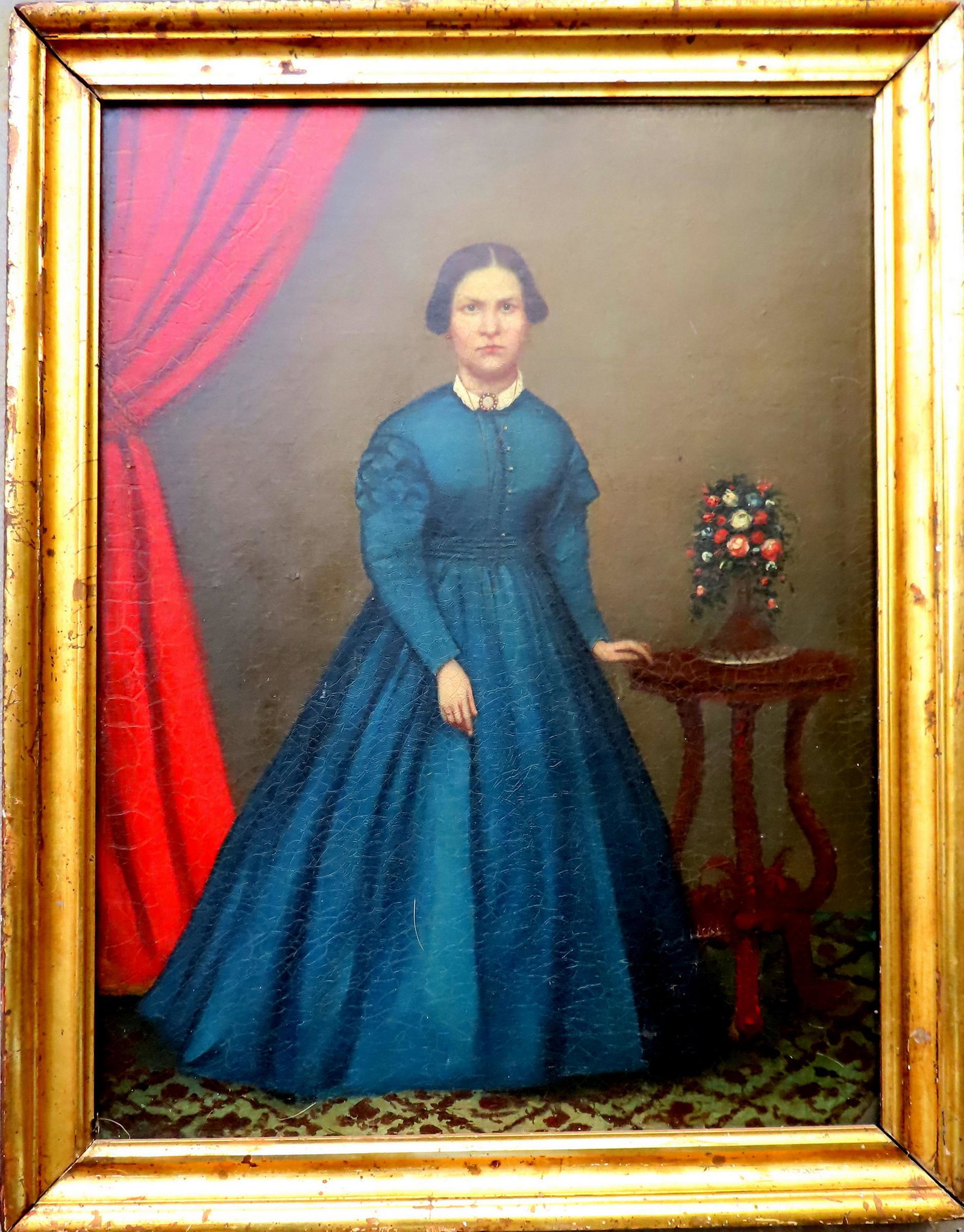 O/C Portrait of lady in blue dress standing by table with vase of flowers, circa 1860 in original: O/C Portrait of lady in blue dress standing by table with vase of flowers, circa 1860 in original lemon gold frame. Crazing which is stabilized and appears to be relined, very good condition. Total fr