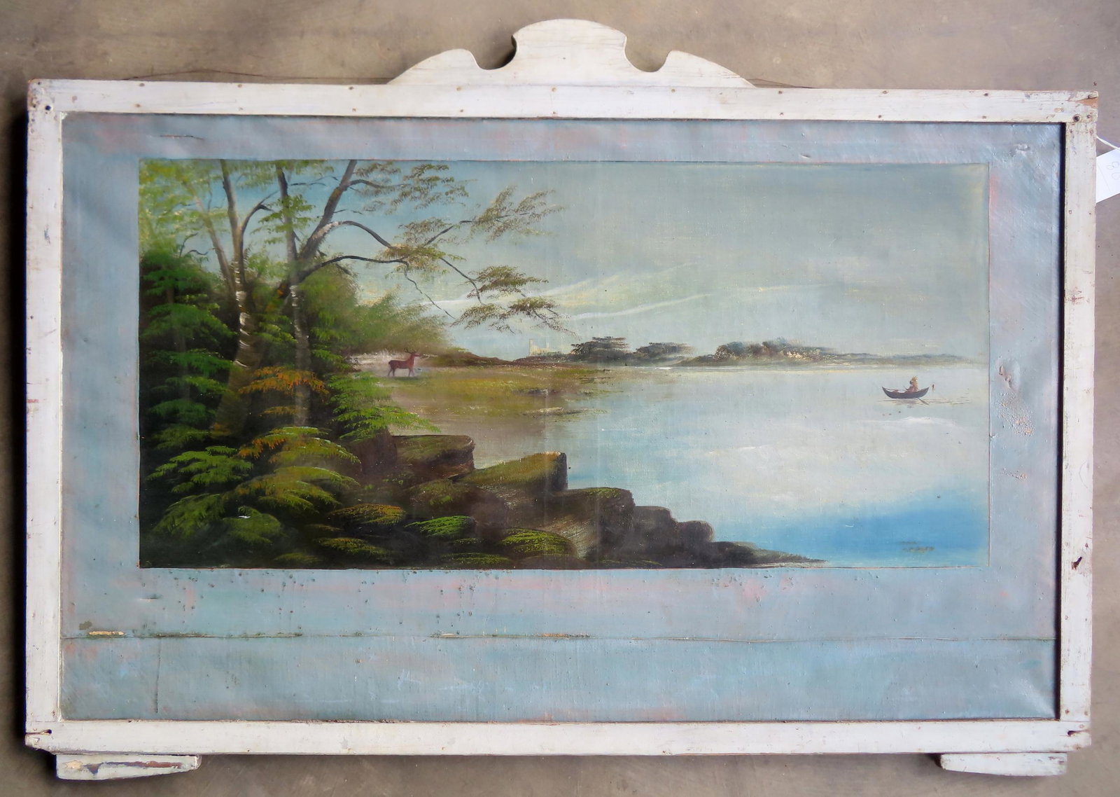 A large primitive O/C Adirondack landscape with deer on shoreline watching Native American paddling: A large primitive O/C Adirondack landscape with deer on shoreline watching Native American paddling canoe in lake - large building in background. Late 19th century mounted in handmade wooden frame tha