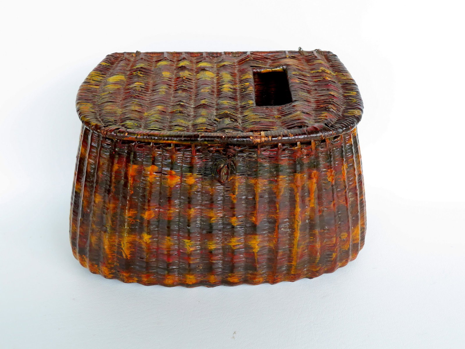 An exceptional early wicker fishing creel with layers of old varnish and decorated with splotches of: An exceptional early wicker fishing creel with layers of old varnish and decorated with splotches of mustard color paint that form concentric rings around the perimeter, 19th century. Missing leather 