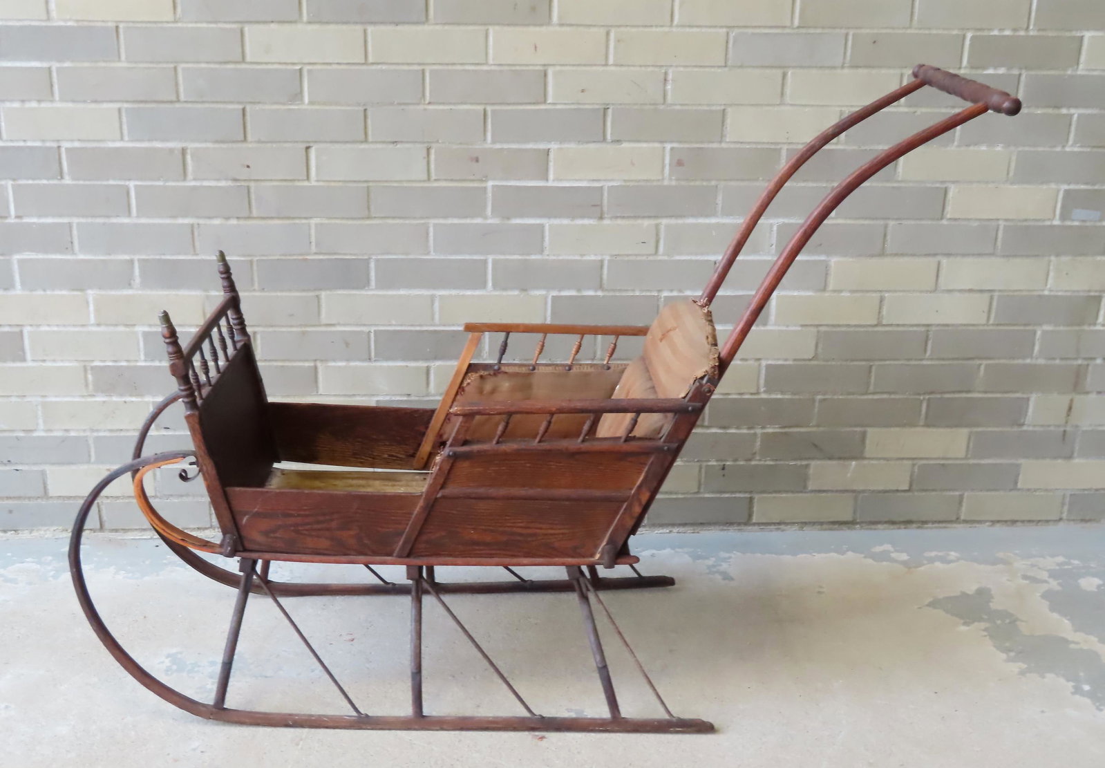 A 19th child's push sled with original upholstery, original natural finish, small break in left: A 19th child's push sled with original upholstery, original natural finish, small break in left front arch support that is protected by the iron runners so sled is still very stable, and minor profess