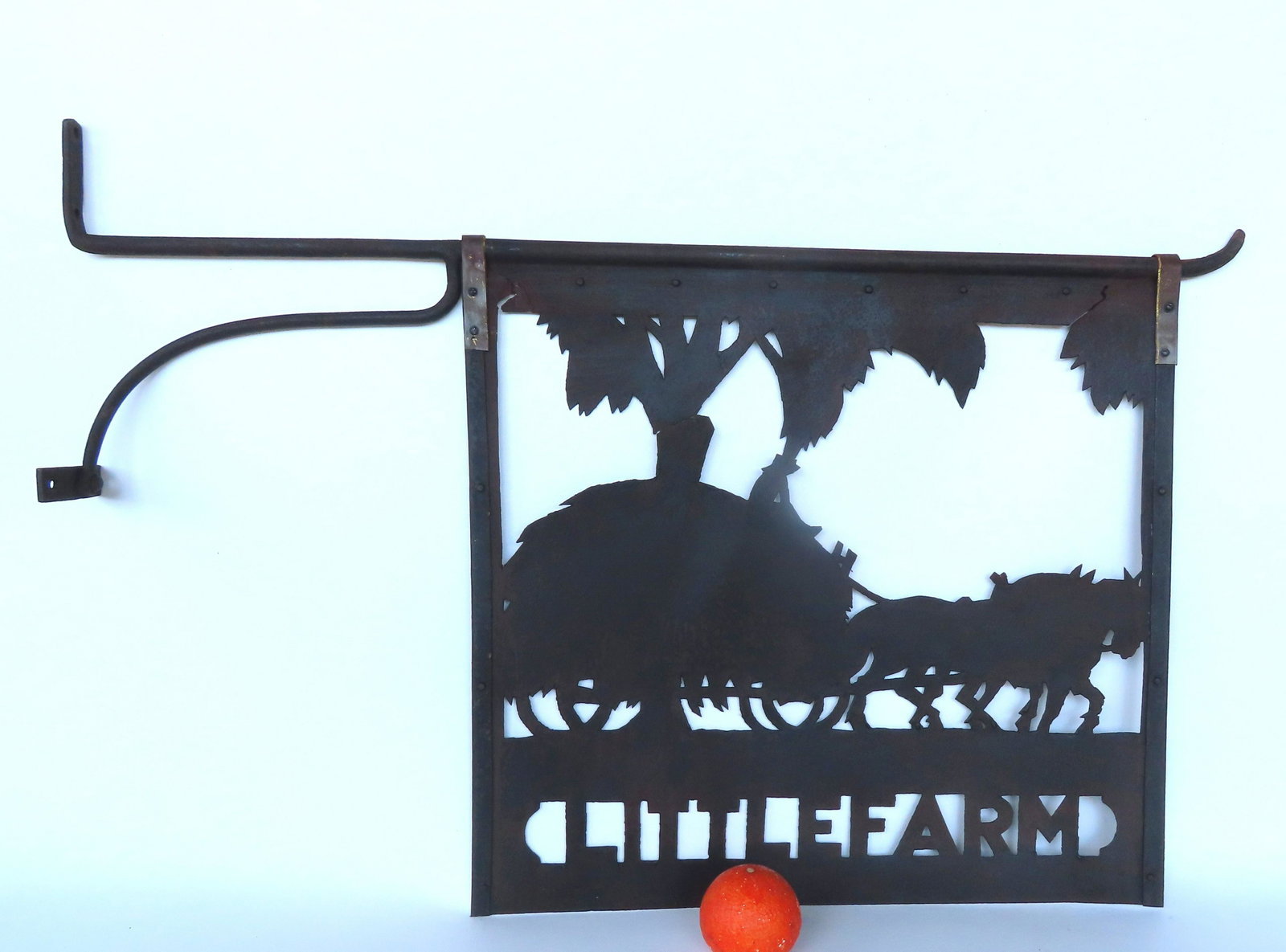 A silhouette folk art tin farm sign depicting a horse drawn hay wagon with rider: A silhouette folk art tin farm sign depicting a horse drawn hay wagon with rider under tree limbs below farm named "LITTLE FARM" - mounted on original post bracket in black paint - frame with stabiliz