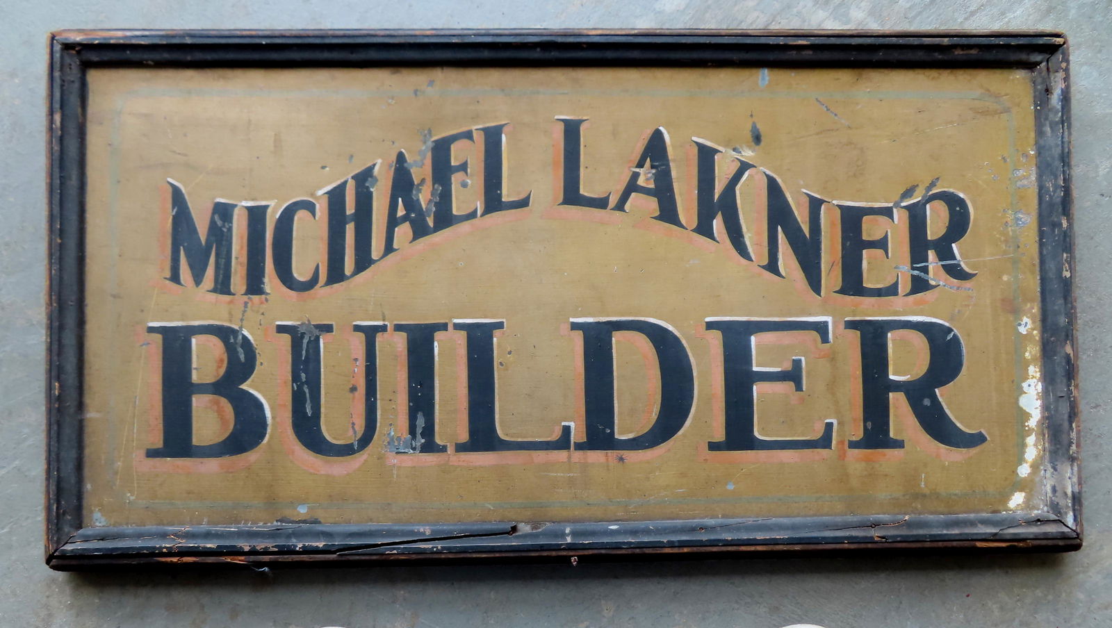 A trade sign marked "Michael Lakner / Builder" on tin with wooden frame, all in original paint.: A trade sign marked "Michael Lakner / Builder" on tin with wooden frame, all in original paint. Minor paint flakes but overall good condition. Circa 1900. Measures 31" x 16".