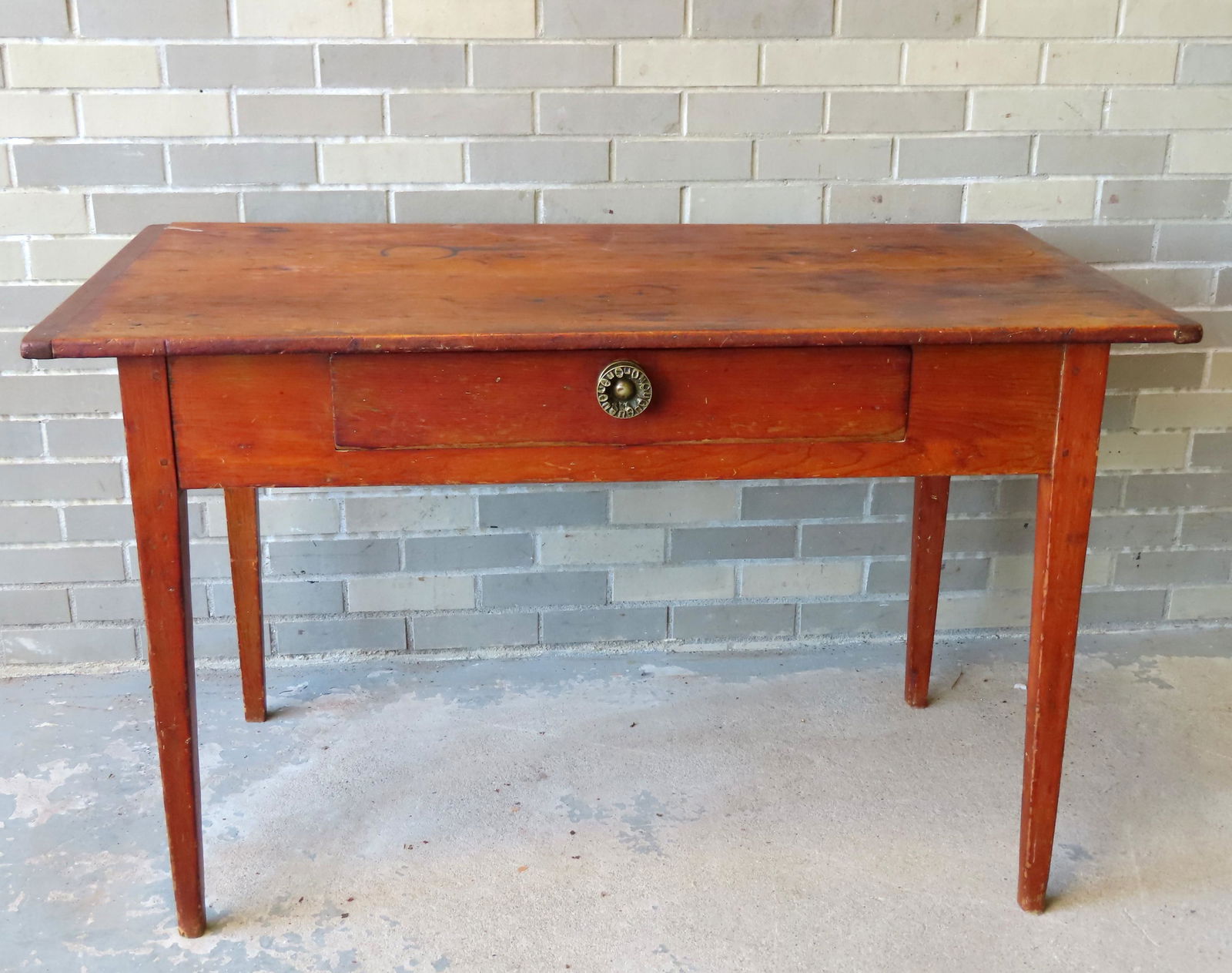 A Hepplewhite poplar wood tap table with center drawer having a brass pull, the top with breadboard: A Hepplewhite poplar wood tap table with center drawer having a brass pull, the top with breadboard ends, circa 1800-20, very good condition. Measures 47 3/4?W x 26"D x 29"H. Provenance: From the esta