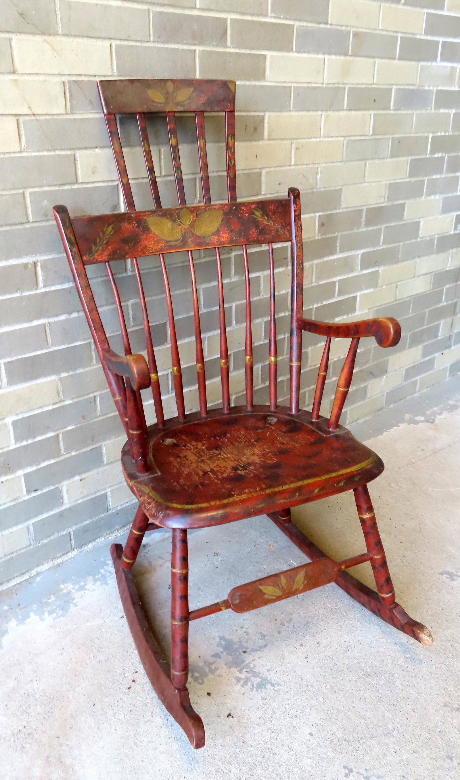 A good Sheraton comb-back rocker in original paint with hand painted flowers across crest, black and: A good Sheraton comb-back rocker in original paint with hand painted flowers across crest, black and red grain painting throughout and yellow pin striping. Paint is slightly worn, wear to front of rig