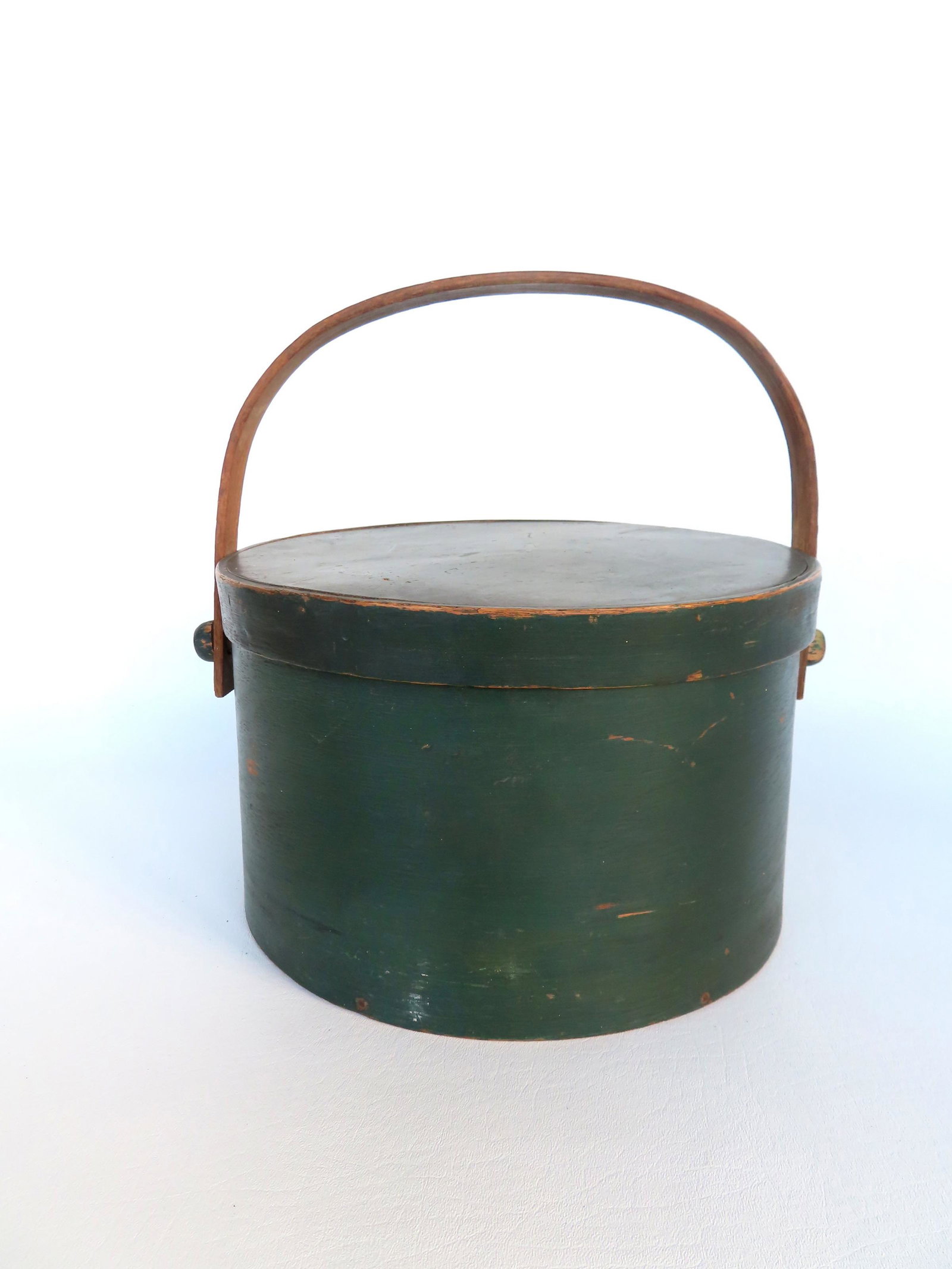 Firkin with wooden swing handle in original green paint, mid 19th century. Several small splits in: Firkin with wooden swing handle in original green paint, mid 19th century. Several small splits in side at lap joint, else good condition. Measures 11 3/4" diameter x 7 1/2"H to top of lid. Provenance