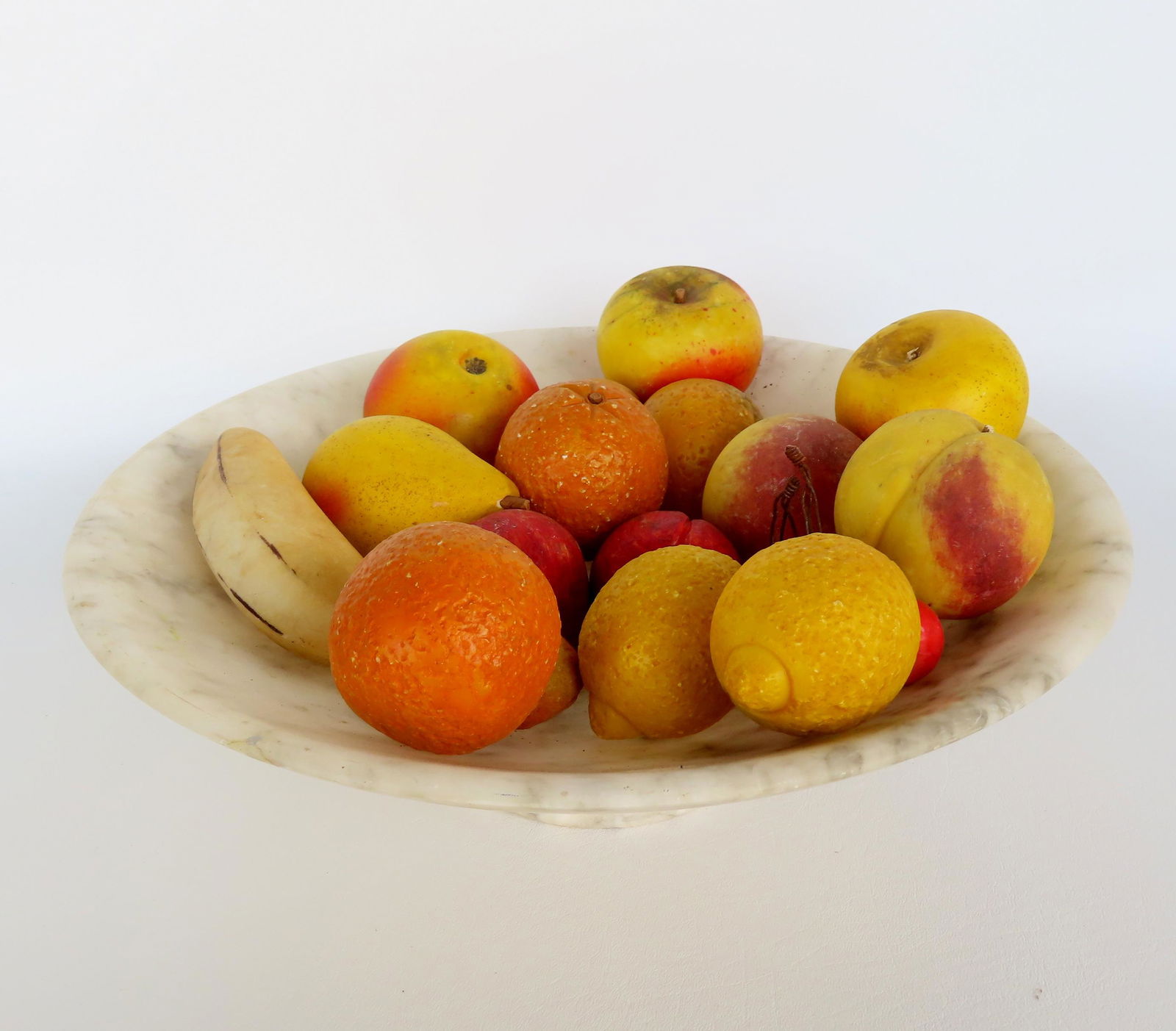 An alabaster bowl with 16 pieces of stone fruit including lemons, oranges, pears, apples and a: An alabaster bowl with 16 pieces of stone fruit including lemons, oranges, pears, apples and a banana. The alabaster bowl measures 13 1/2" diameter x 4"H. The fruit and bowl are all in very good condi