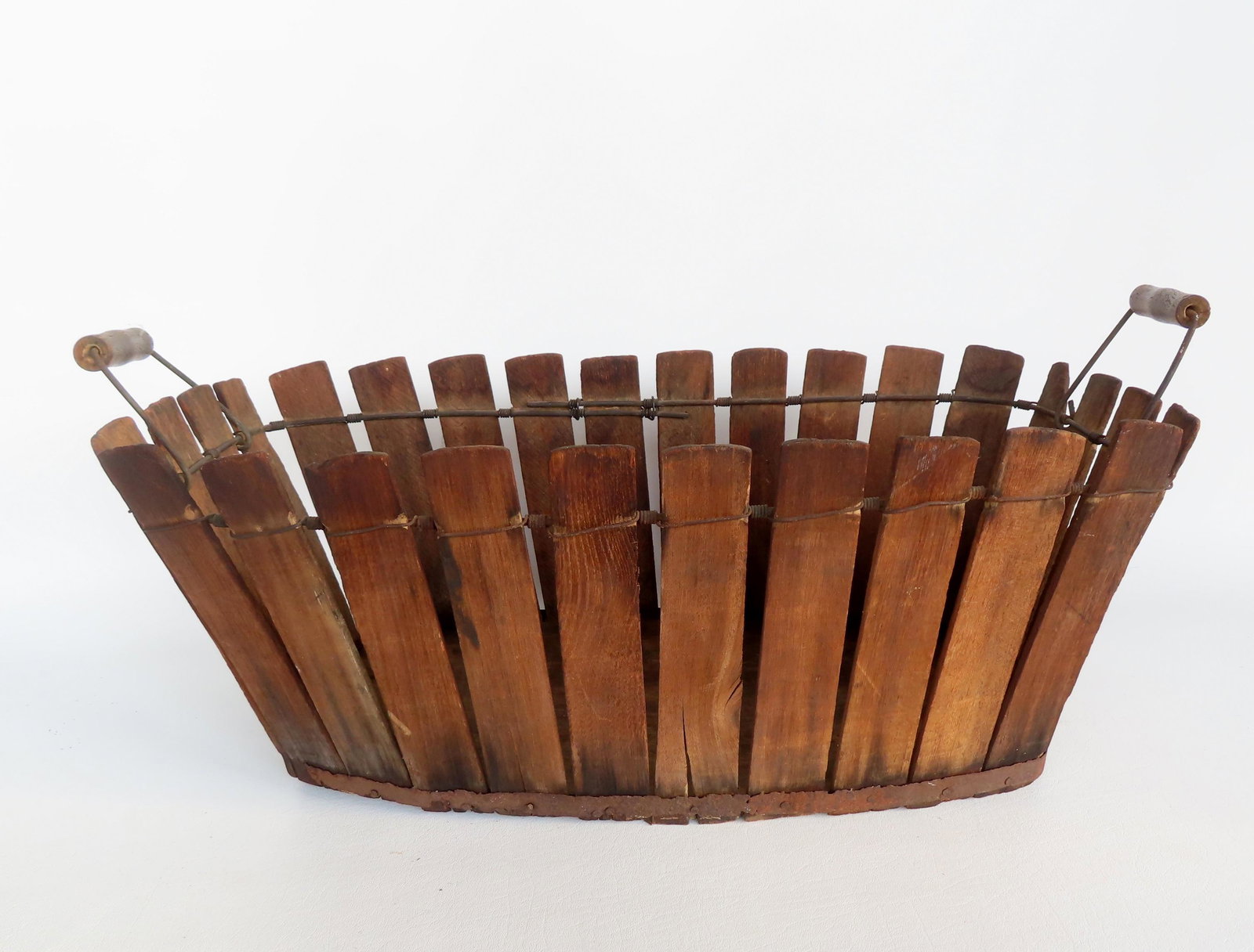A Shaker slatted basket with original bale handles, late 19th to early 20th century. Good condition.: A Shaker slatted basket with original bale handles, late 19th to early 20th century. Good condition. Measures 23 1/2"L x 12"W x 9"H.