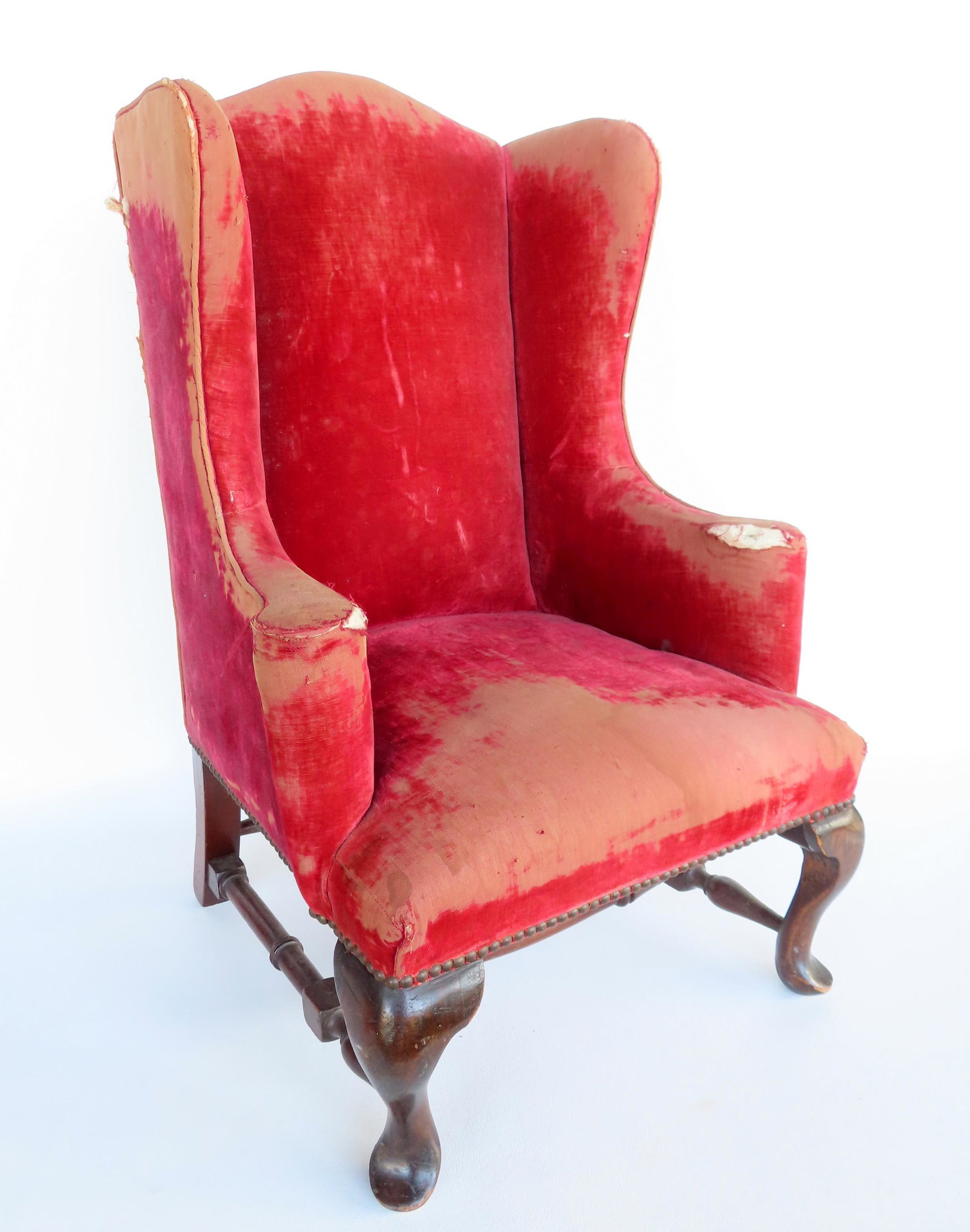 An unusual child's upholstered Queen Ann style wing chair with cross stretchers, custom made: An unusual child's upholstered Queen Ann style wing chair with cross stretchers, custom made probably late 19th to early 20th century. Extensive wear to the upholstery, but good structural condition. 