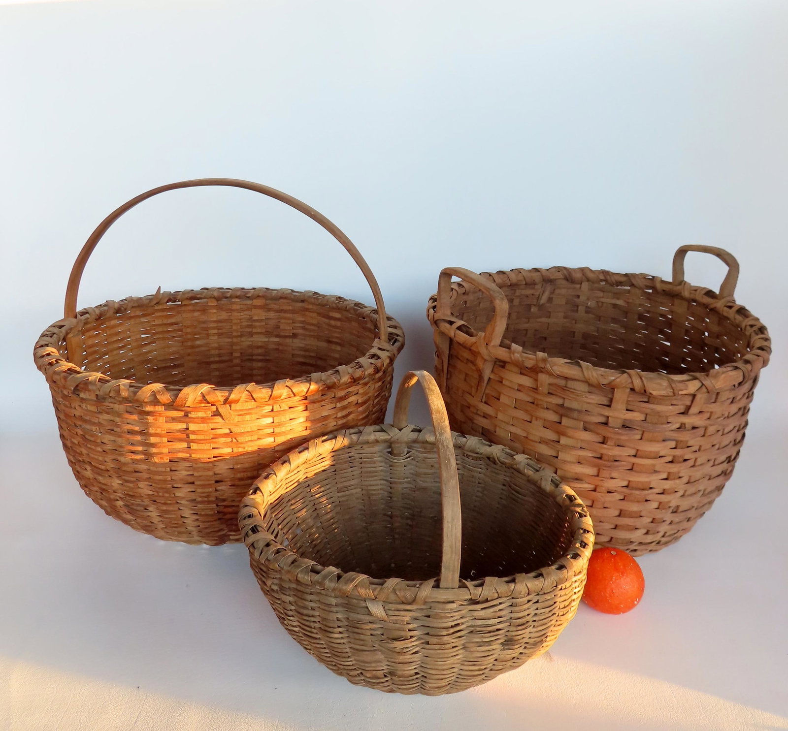 Three field baskets including 2 Taghkanic, all in good condition and believed to be late 19th: Three field baskets including 2 Taghkanic, all in good condition and believed to be late 19th century with good patination and crisscrossed rims. The first, with 2 arched handles, several splint break