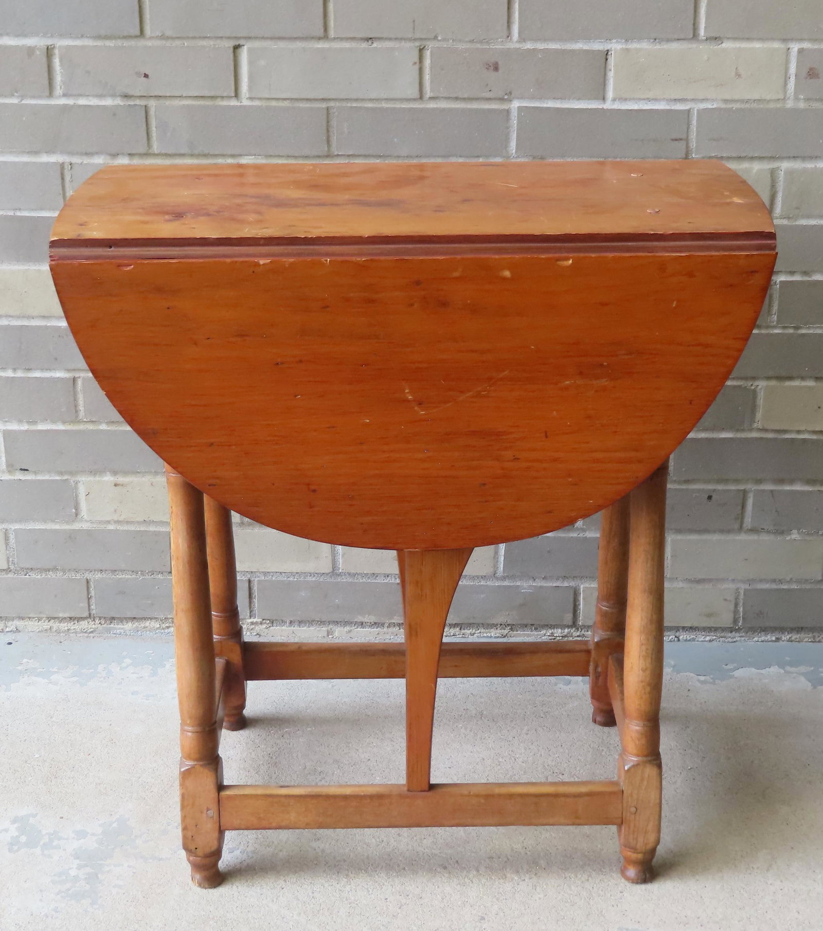 A small butterfly table in maple and pine with cross stretchers, original button feet, and replaced: A small butterfly table in maple and pine with cross stretchers, original button feet, and replaced drawer, 18th century. Note the different coloring on the drop leaves from that of the top indicating