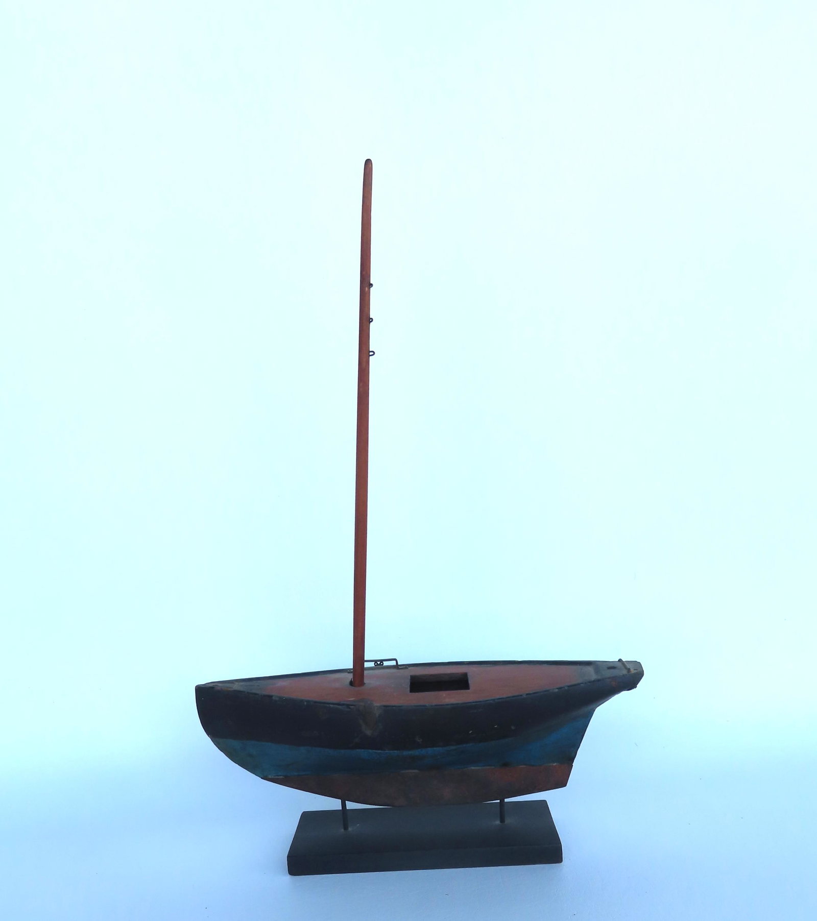 A ship model, missing rigging and other parts, the hull in original blue and black paint with iron: A ship model, missing rigging and other parts, the hull in original blue and black paint with iron keel. The boat on stand measures 13 5/8"L x 4 3/8"D x 20 3/4"H. Provenance: From the Nancy & Elliott 