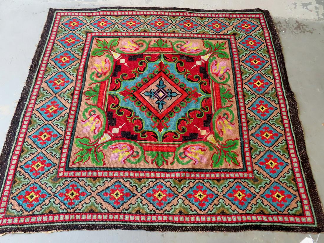 A hand embroidered textile with silk backing, either a table rug or wall hanging: A hand embroidered textile with silk covering on reverse side, yarn sewn which appears to be cross stitched into a background fabric, either a bed cover or wall hanging and not meant for use on the fl