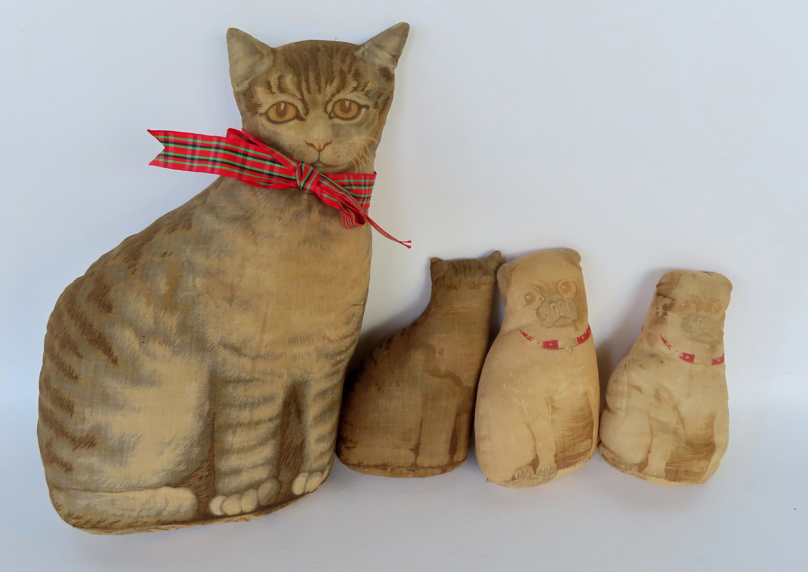Grouping of 4 stuffed pattern cloth dolls, probably Arnold Print Works 1892: Grouping of 4 stuffed pattern cloth dolls, probably Arnold Print Works 1892, including a large cat 14"H x 8"W - very good condition; a small cat 7"H - soiling but no damage to fabric; and 2 small dogs