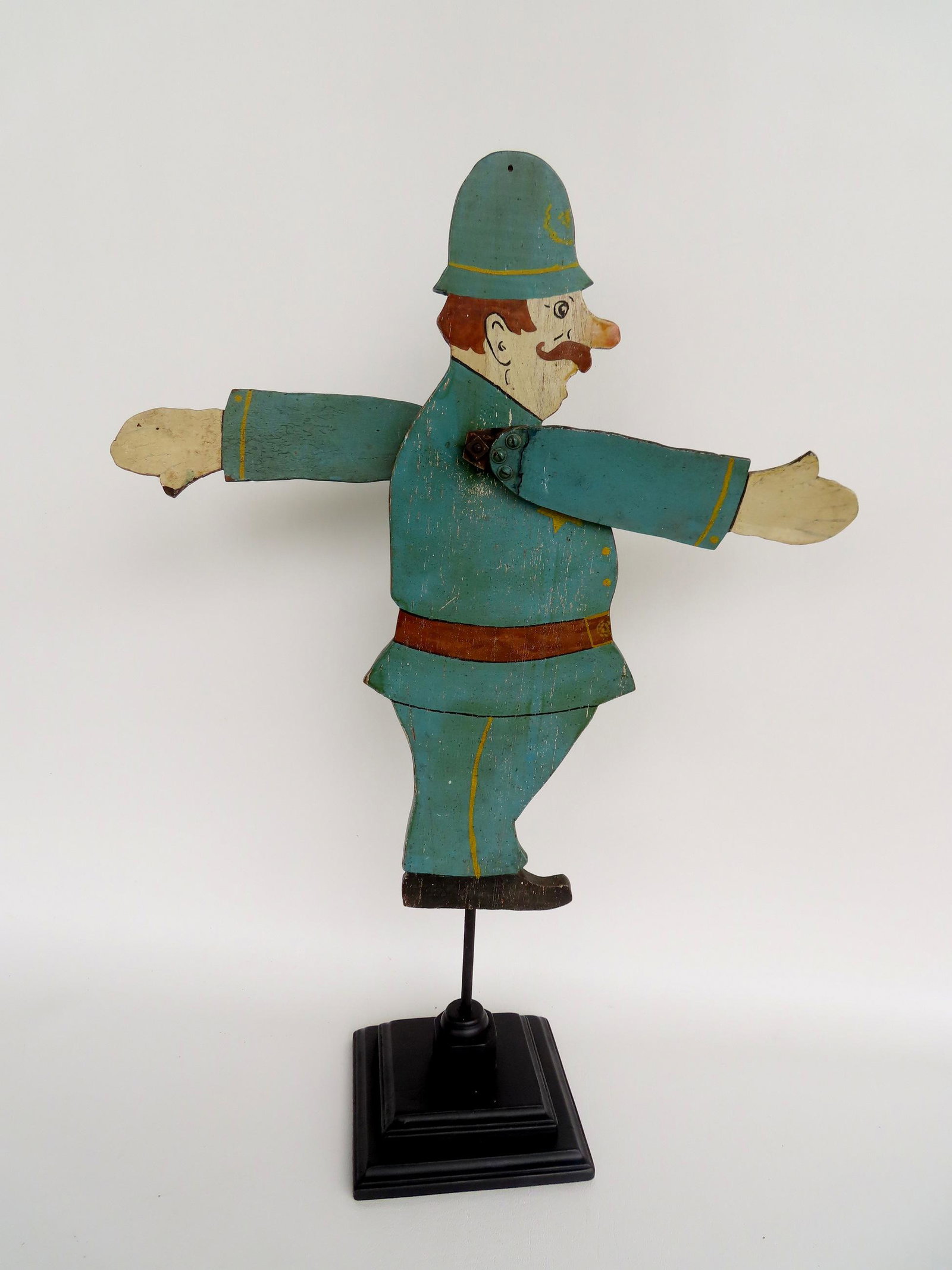 A whirligig of a Keystone Cop, circa 1920-30. Repair to one arm, else good condition in original: A whirligig of a Keystone Cop, circa 1920-30. Repair to one arm, else good condition in original paint and mounted on a modern stepped base for display purposes. 19"W (with arms fully extended) x 7 1/