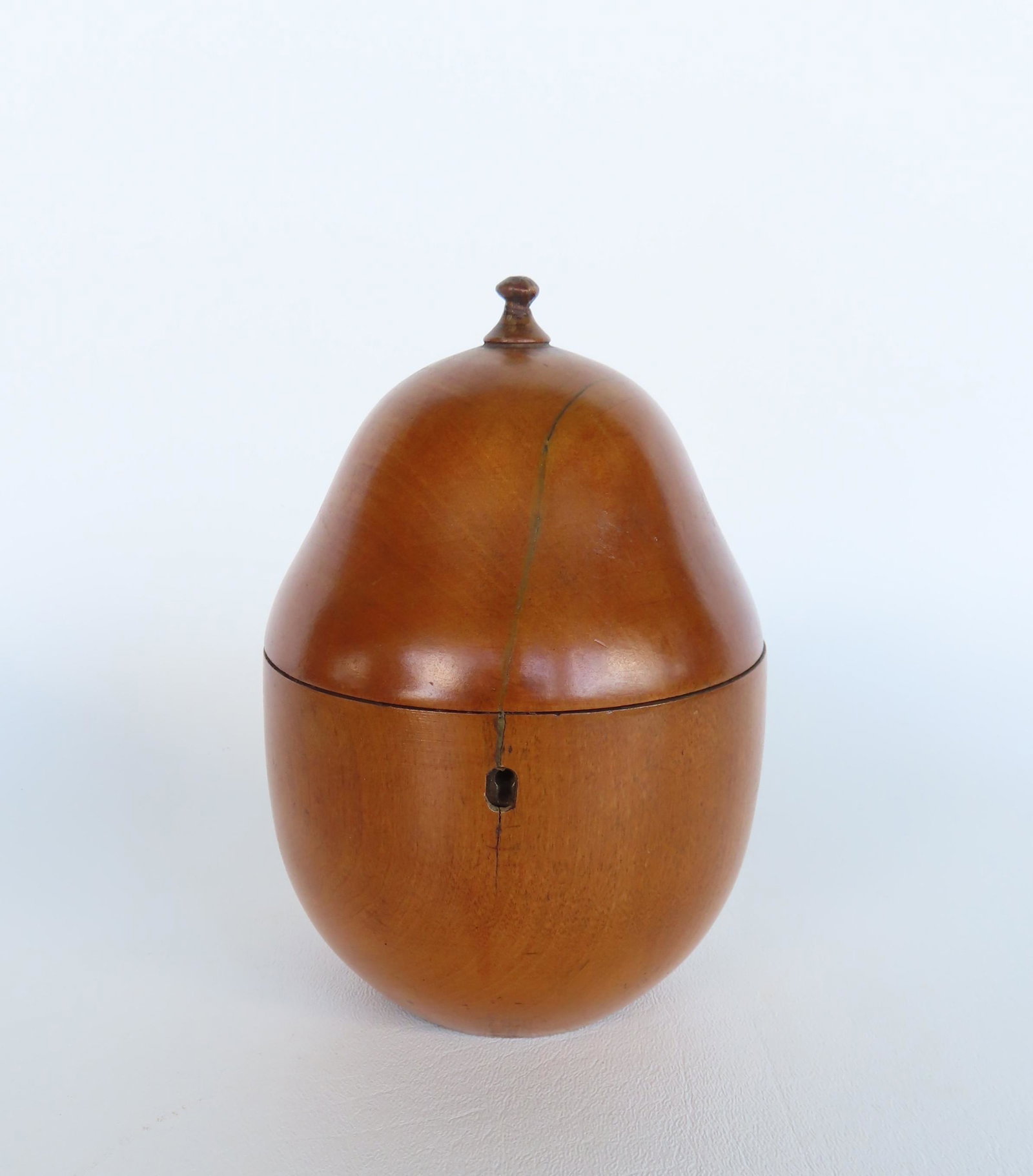 A pear shaped tea caddy, original lock but no key, early 19th century. Tight hairline extending from: A pear shaped tea caddy, original lock but no key, early 19th century. Tight hairline extending from top of lid across lock, and small hairline on back side, otherwise good condition - 6 1/4"H.
