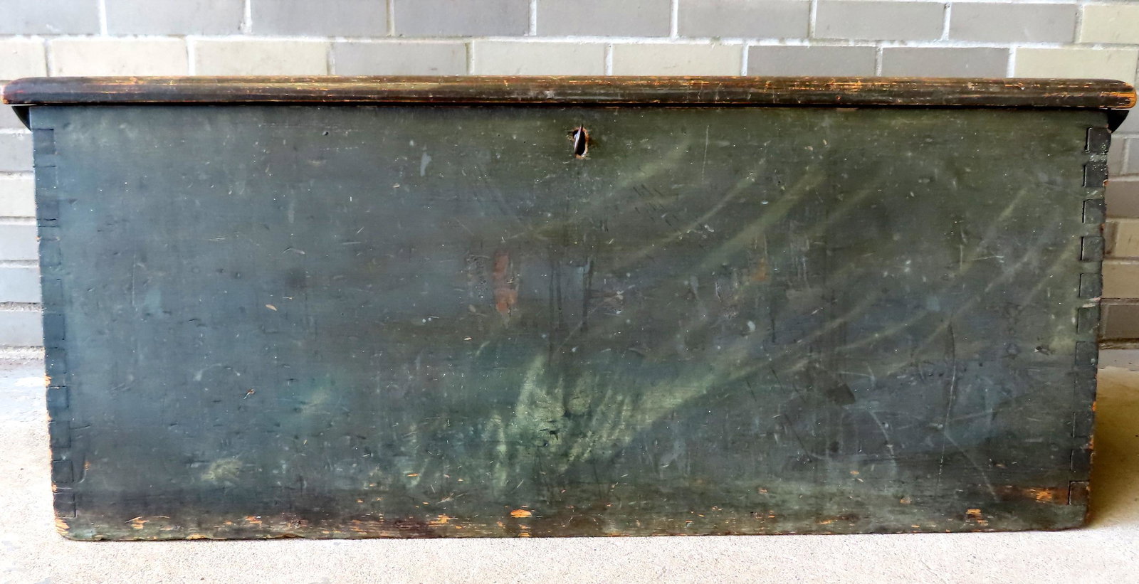 A very fine primitive sea chest in original green paint with original beckets attached to shaped: A very fine primitive sea chest in original green paint with original beckets attached to shaped wooden handles, end cleats attached to underside of lid, late 18th century. Dovetailed case and origina