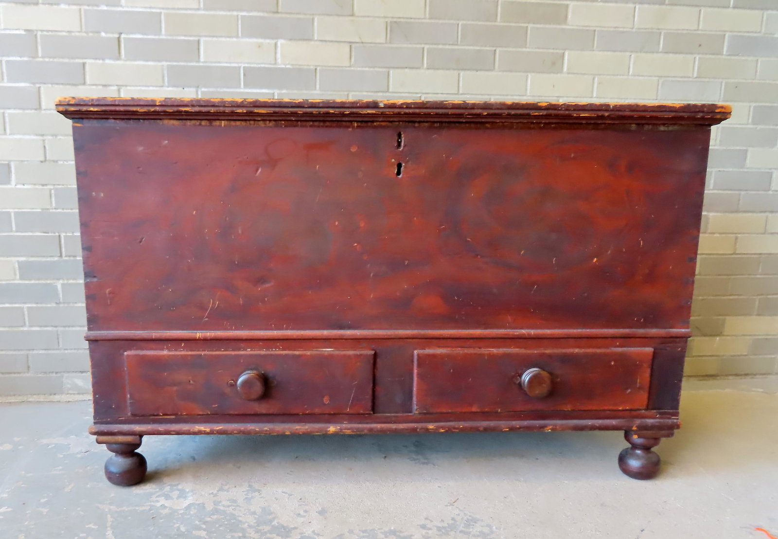 A large grain painted blanket box with internal till, original lock, 2 lower drawers, mounted on: A large grain painted blanket box with internal till, original lock, 2 lower drawers, mounted on turned ball feet. Early to mid 19th century. Expansion crack in lid, else very good condition. Measures
