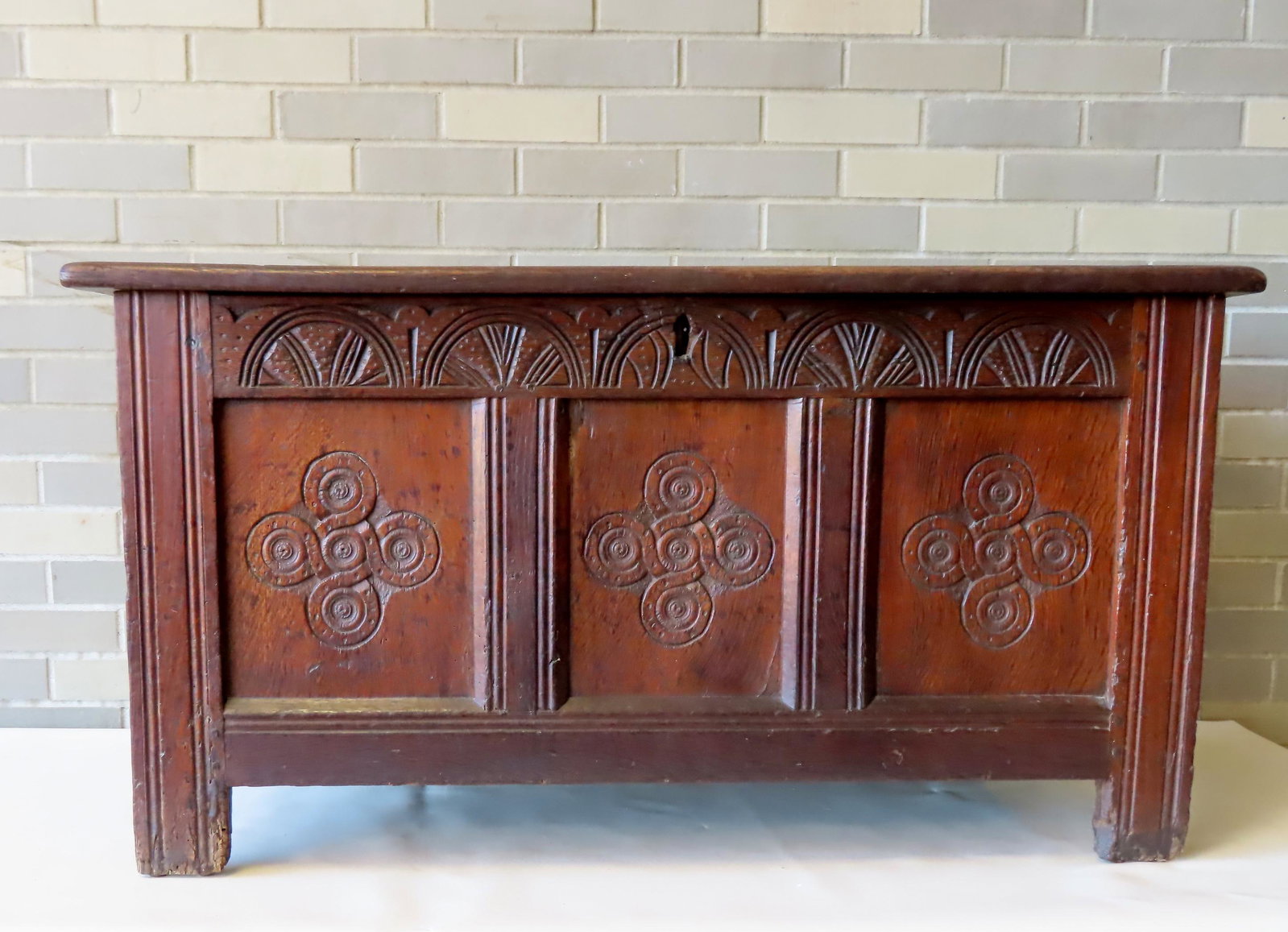 An early oak blanket box having small hand forged iron hinges, mortise and tenon construction on: An early oak blanket box having small hand forged iron hinges, mortise and tenon construction on case, and rose head nails on underside of base. The lid with molded edge and double panels, the front w