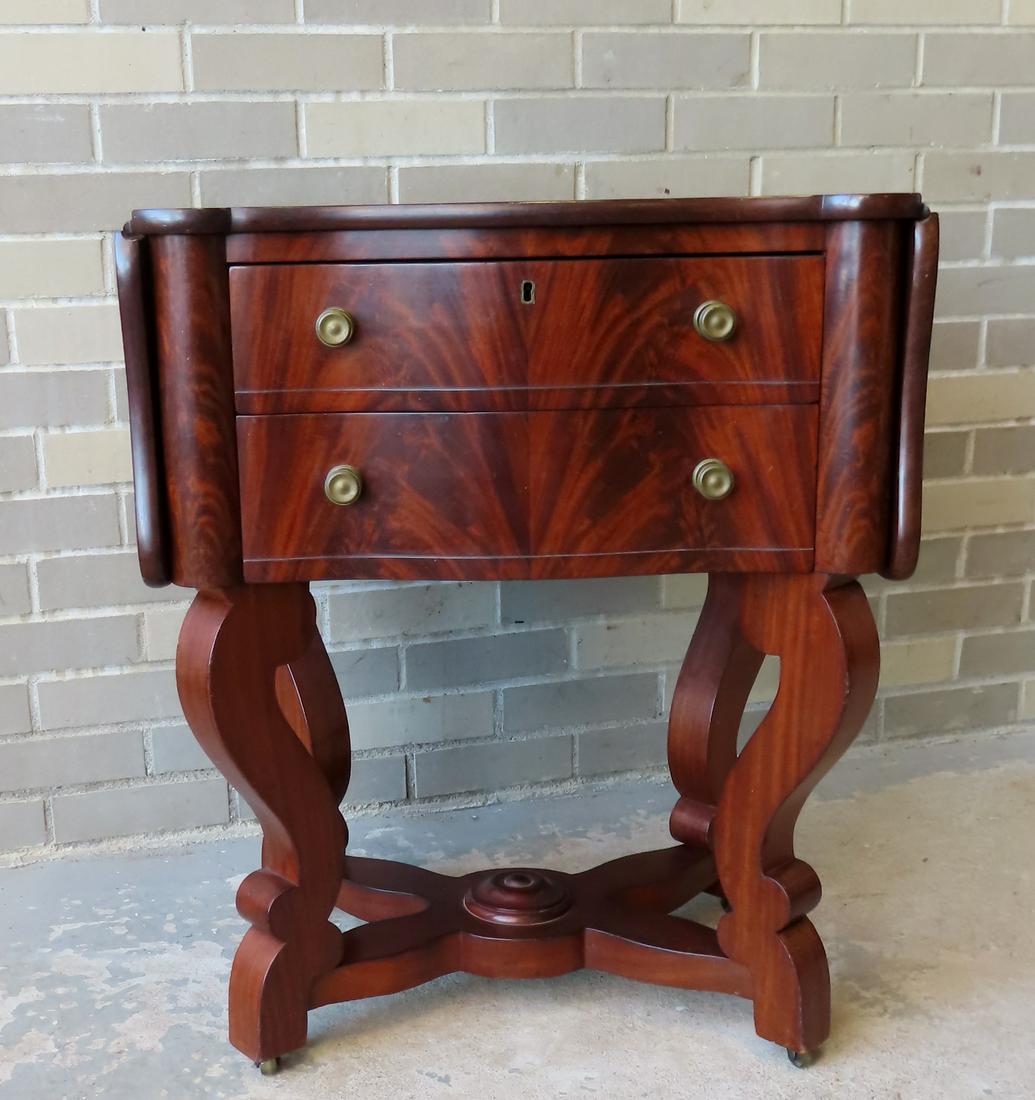 An Empire mahogany 2 drawer drop leaf sewing with serpentine front, scrolled legs and lower spider: An Empire mahogany 2 drawer drop leaf sewing with serpentine front, scrolled legs and lower spider leg platform. Very good condition, circa 1860. Measures 43 3/4"W (leaves up) x 23"W (leaves down) x 1