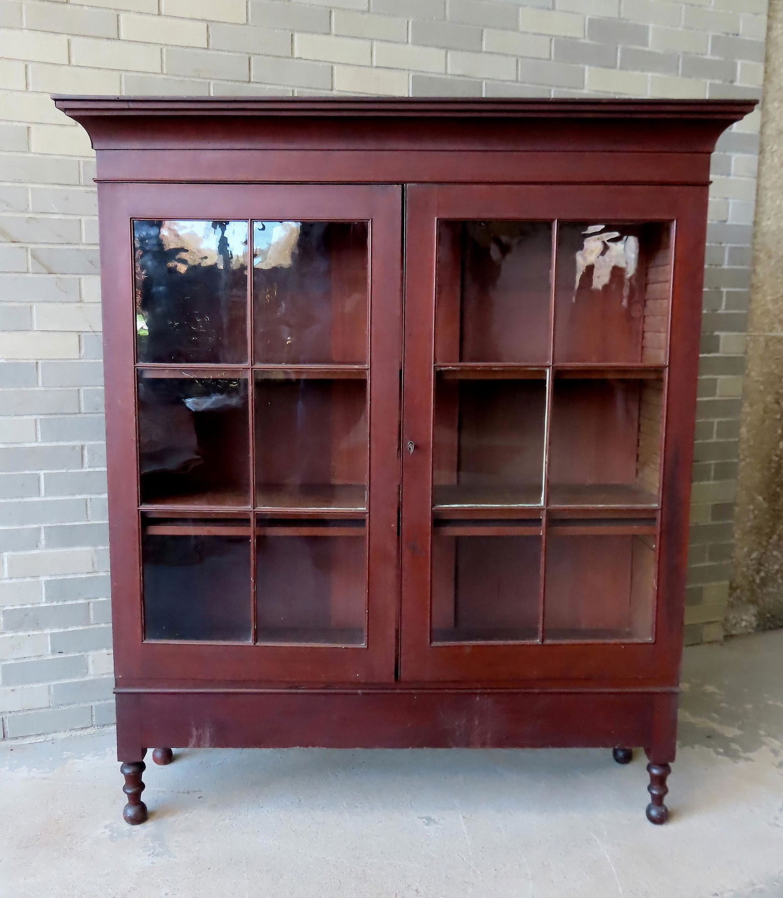 A very fine 2 door mahogany bookcase, each door with 6 lights (note the molded mullions), shaped: A very fine 2 door mahogany bookcase, each door with 6 lights (note the molded mullions), shaped cornice and mounted on turned legs, circa 1830-50. Very good condition and retains an old, possibly ori