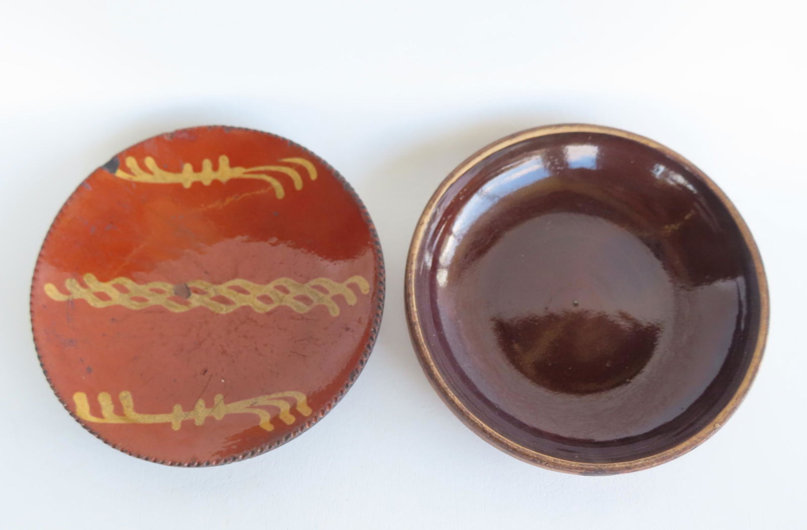 A redware plate with coggled edge and yellow slip decoration, probably Pennsylvania 19th century -: A redware plate with coggled edge and yellow slip decoration, probably Pennsylvania 19th century - several small rim chips, glazing chip, small tight hairline exiting from rim, overall good condition