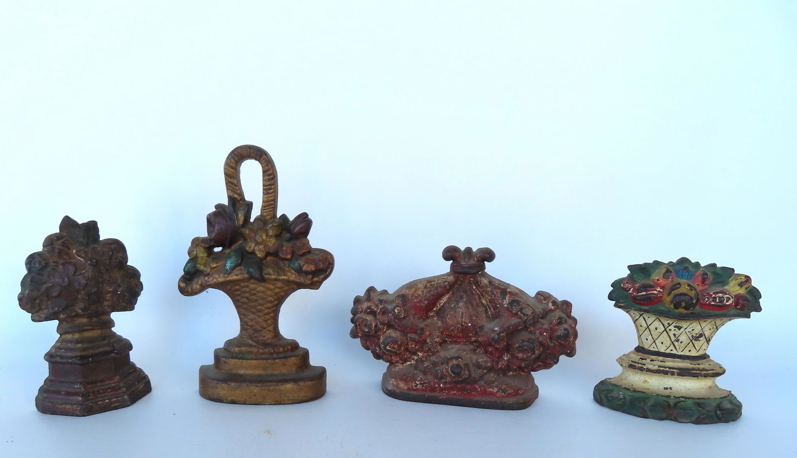 Four cast iron floral door stops in original paint. Some paint wear, buy overall good condition.: Four cast iron floral door stops in original paint. Some paint wear, buy overall good condition. Early 20th century. The largest depicting a double bouquet of flowers in worn paint, measures 5"H x 7 3