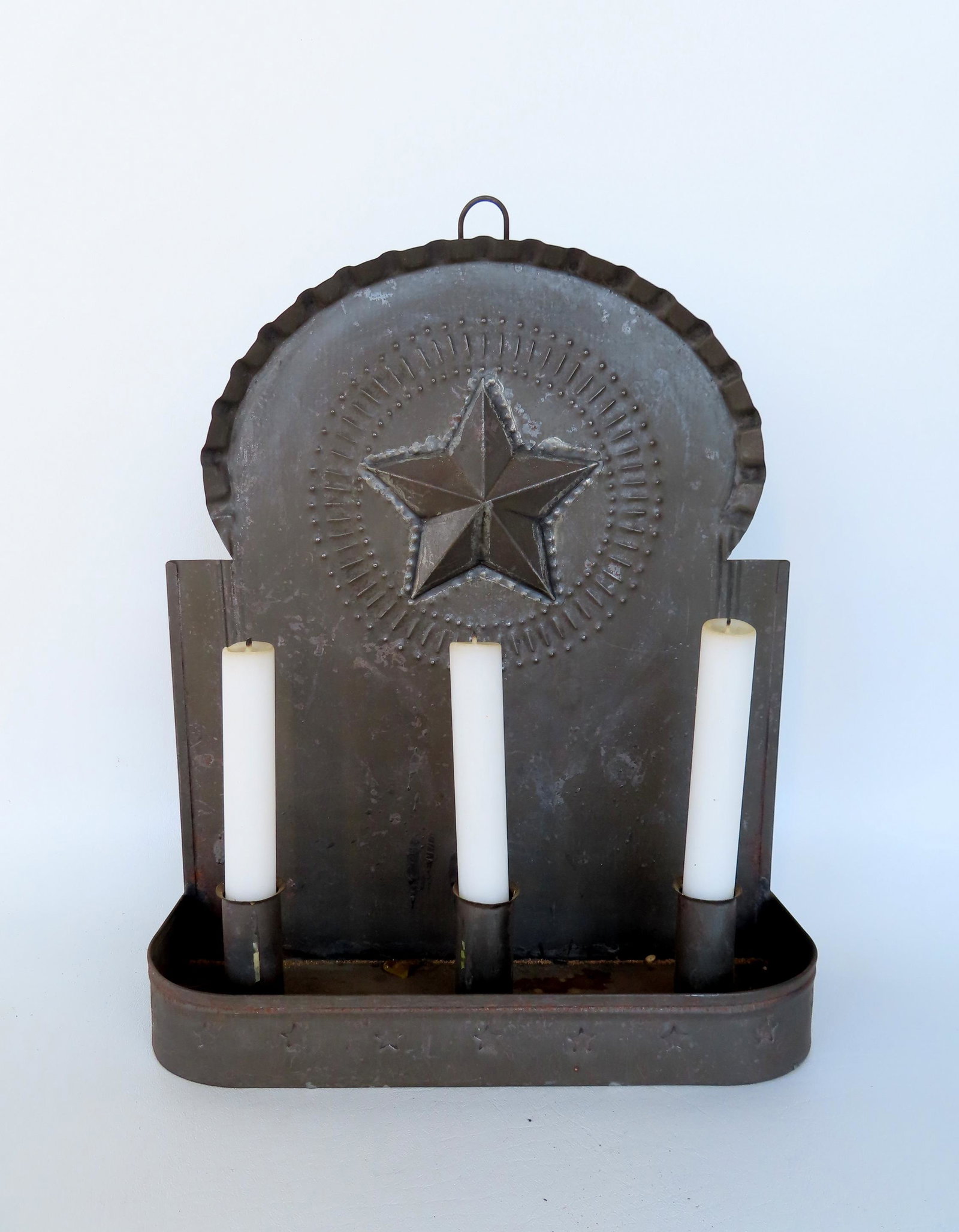 A custom made tin triple font candle wall sconce decorated with pressed stars across the front: A custom made tin triple font candle wall sconce decorated with pressed stars across the front apron and a crest having an applied (soldered) star within a circular board with extending rays, probably