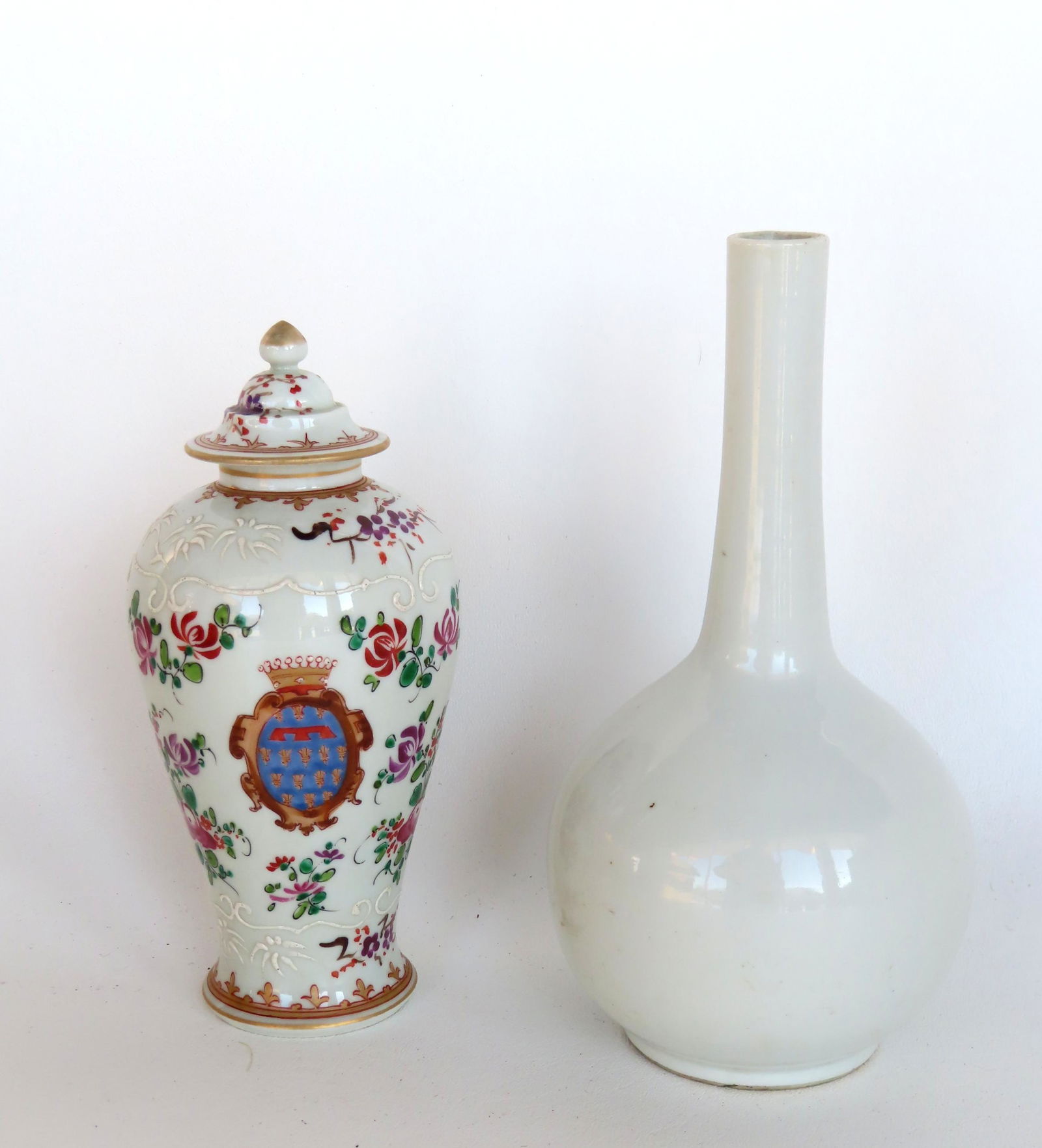 Two porcelain vases, hand painted. The first, a Chinese long neck white bottle vase, oriental: Two porcelain vases, hand painted. The first, a Chinese long neck white bottle vase, oriental signature on base in blue as well as paper label identifying period as Tao-Kuang (1821-1850) - signature h
